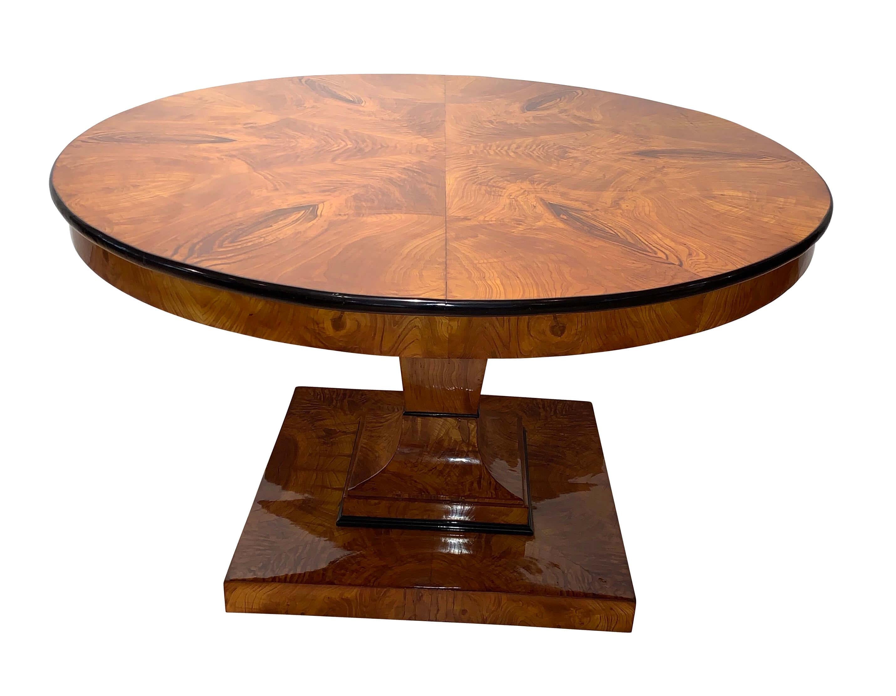 Original, big, round Biedermeier dining room table / saloon table from Vienna, circa 1825.

Wonderful ash veneer at the plate and apron, elaborately hand-polished with shellac. Edge of the plate has been ebonized and polished.
Lovely, well