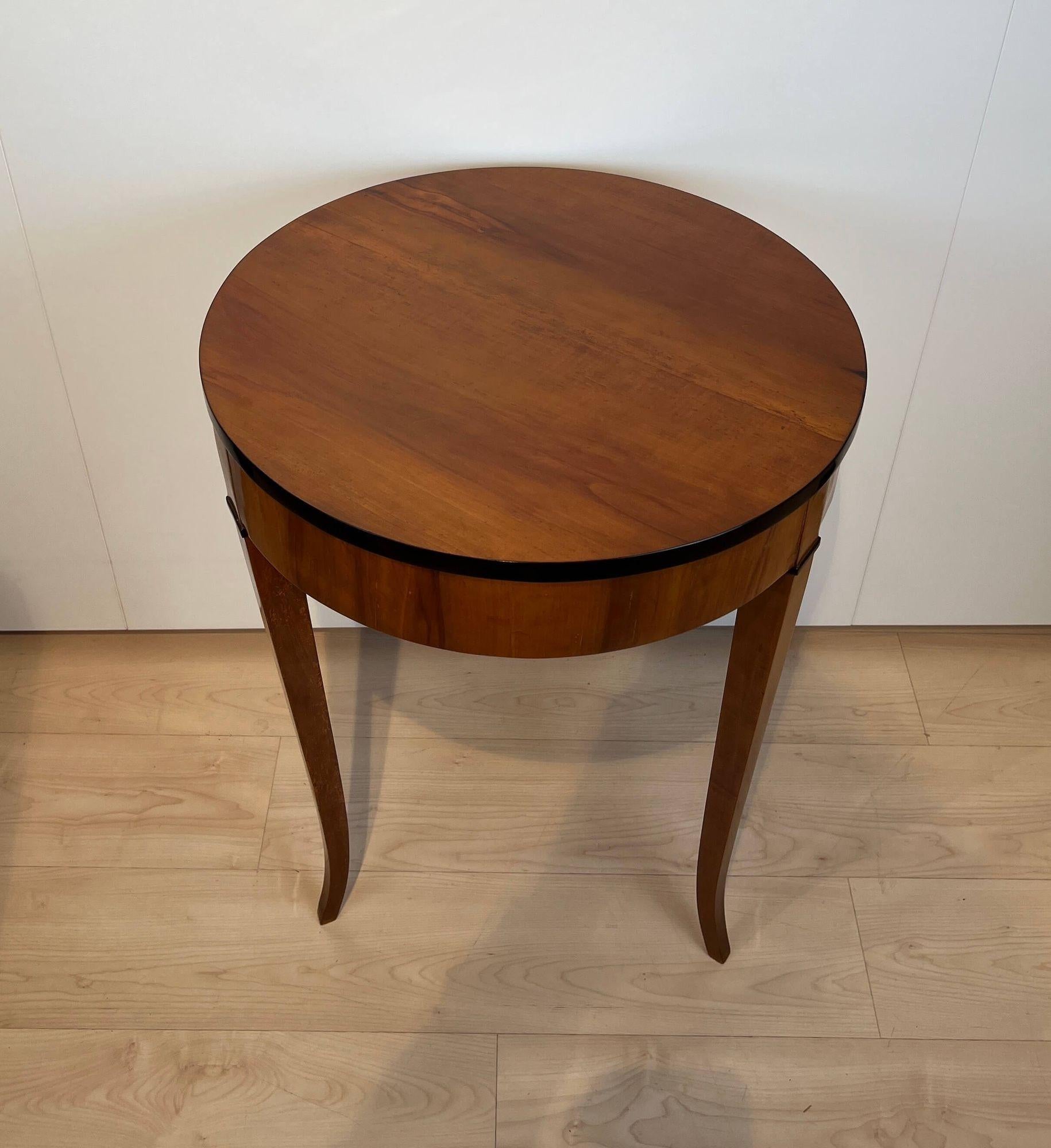 Round Biedermeier side table, cherrywood, South Germany, circa 1820.
 
Solid cherry wood at the top and legs and veneered at the frame.
Restored and hand polished with shellac. Partly ebonized.
 
Dimensions: H 76,5 cm , Ø 56 cm.