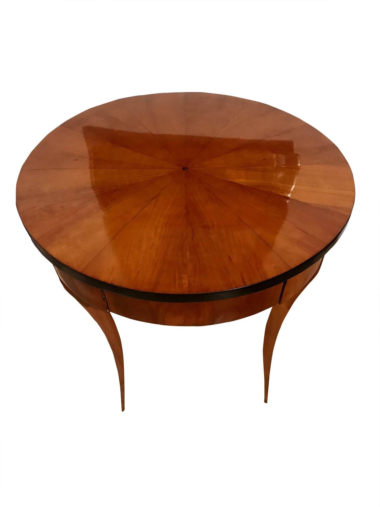 Elegant, round Biedermeier side table with star shaped cherry veneer at the plate. This early Biedermeier table dates back to circa 1820 and has been manufactured in South Germany. It has a drawer at the front and very elegant, light, conical