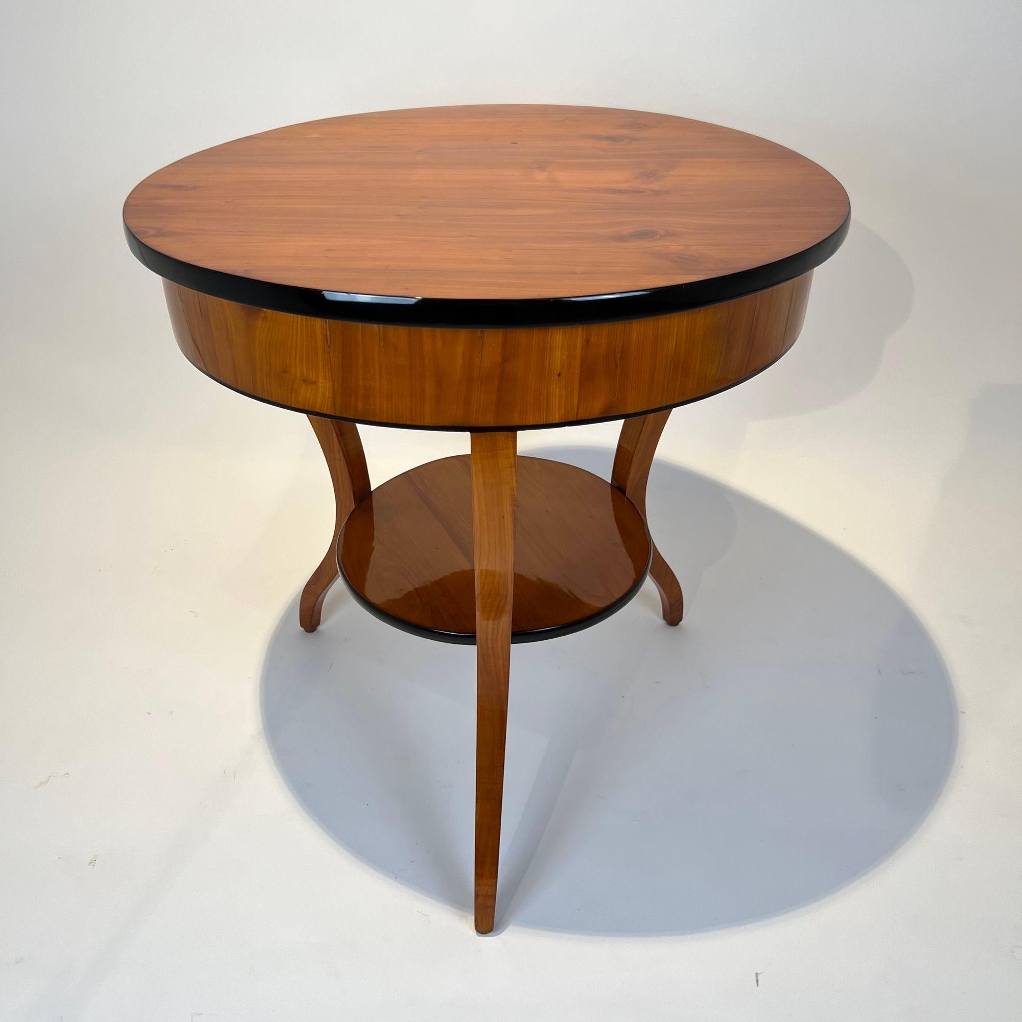 Großer Biedermeier Beistell-, Näh- oder Couchtisch aus Süddeutschland um 1820.

Kirsche furniert auf Weichholz und massiv. Teilweise ebonisiert.
Eine Schublade mit Innenfächern, Schloss und ebonisierter Schlüsselrosette.
Drei geschwungene