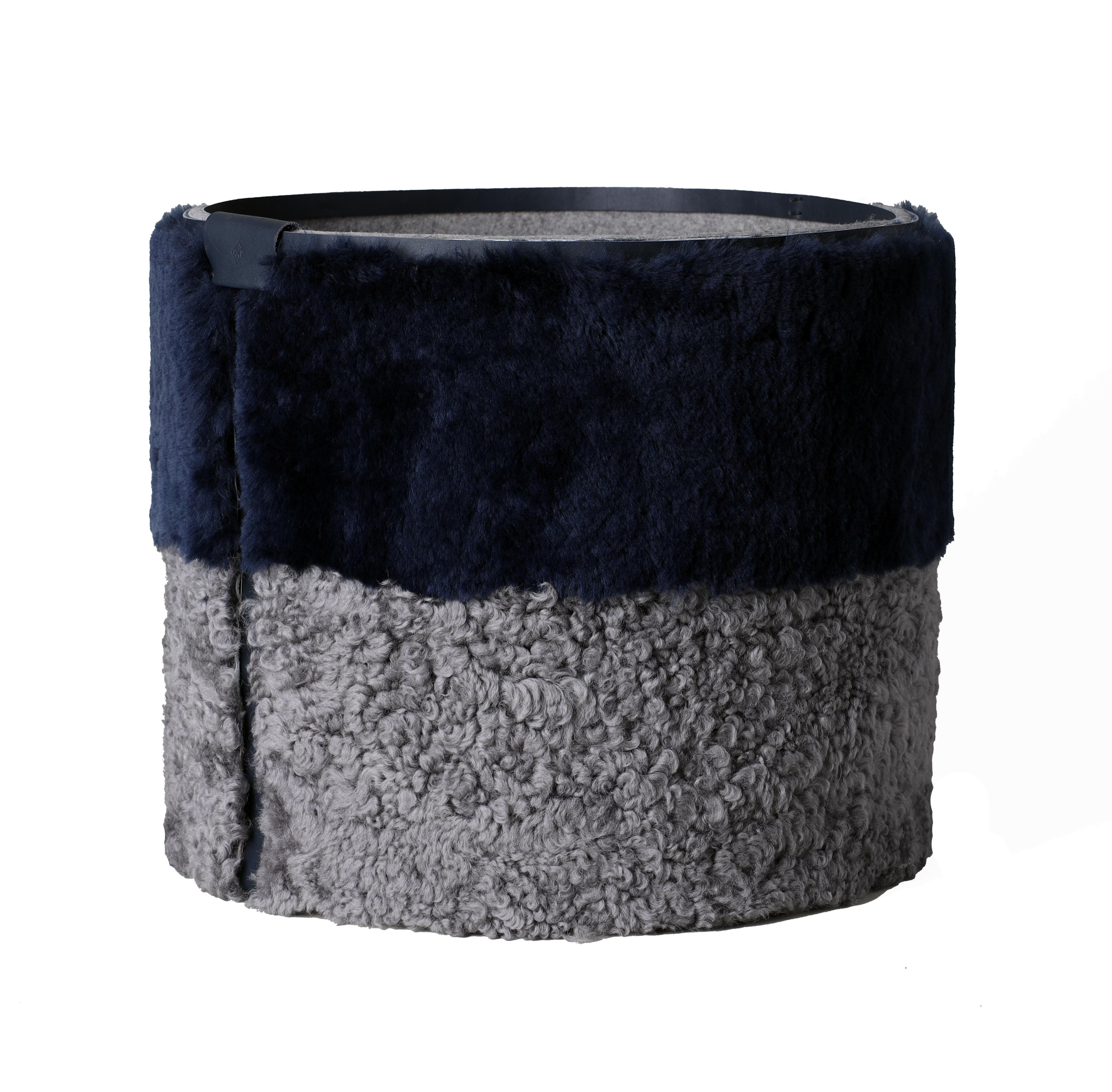 Storage can be luxurious! The Round Bin X is meticulously crafted to combine functionality with aesthetic appeal. The exterior has two-tones of shearling. The top panel is plush and the lower panel is curly with leather detailing and a subtle