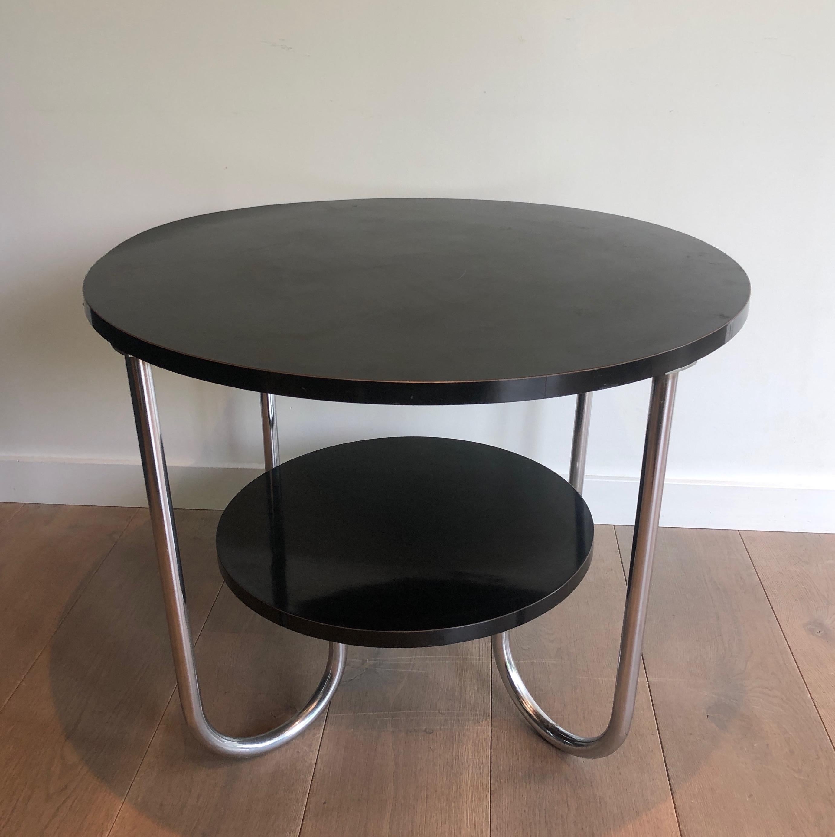 This round gueridon is made of a black plastic film on wood and Chrome. This is a French work, in the style of Marcel Breuer. Circa 1950.
