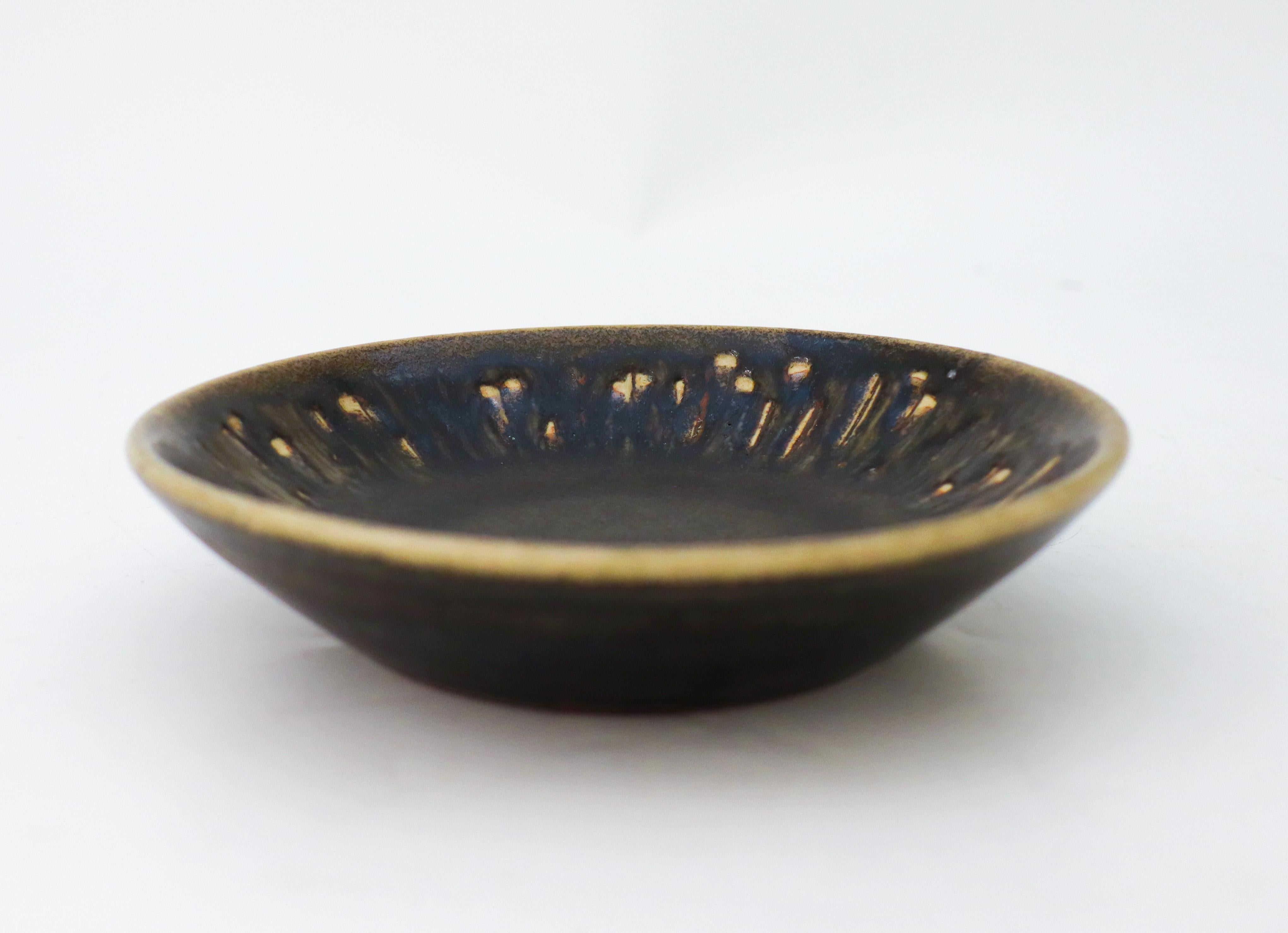 A round, black ceramic bowl designed by Carl-Harry Stålhane at Rörstrand, the bowl is 15,5 cm (6,2