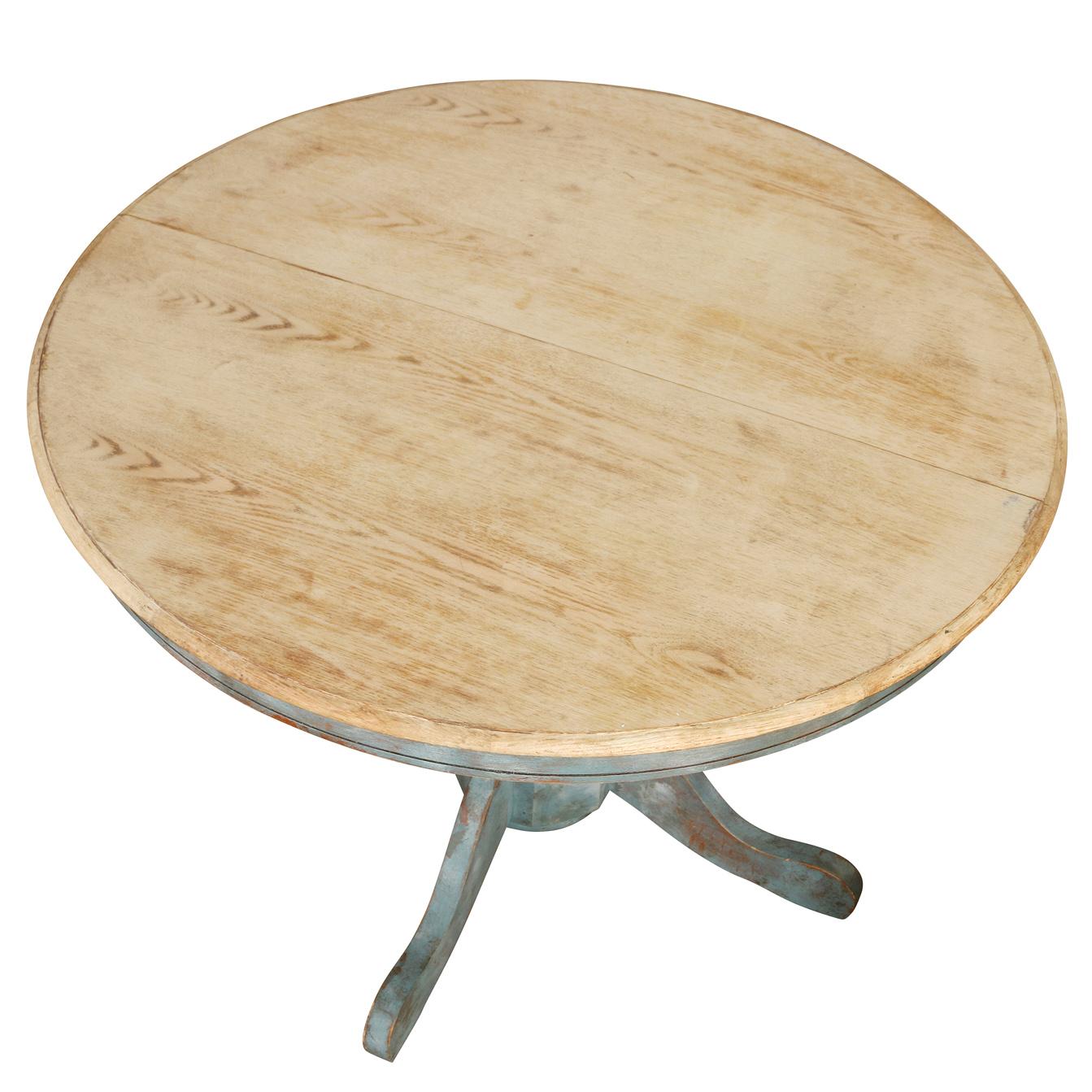 This Round Pedestal Dining Table combines rustic charm with modern versatility. Featuring a bleached oak tabletop, the natural wood grain adds warmth and texture, while the pedestal base, painted in a charming  blue, brings a pop of color and