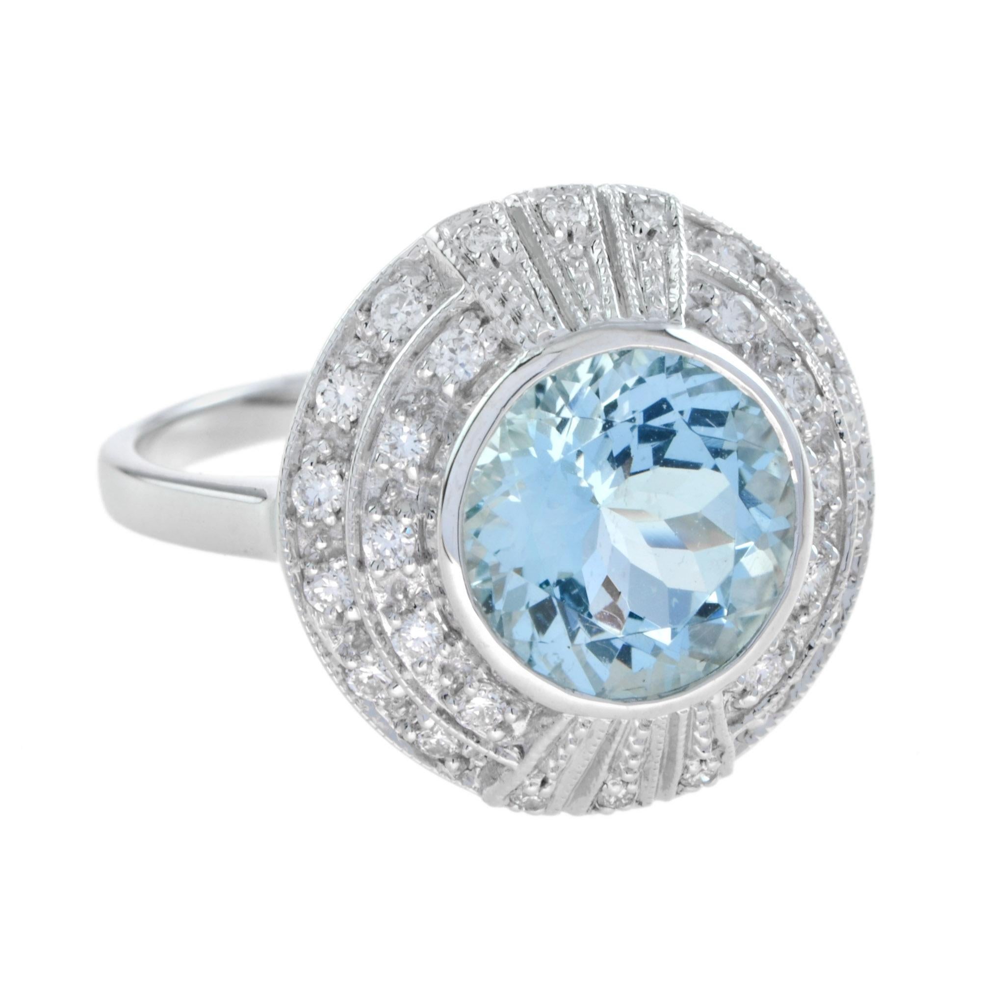 A classic Art Deco inspired cluster design ring with a round aquamarine and a halo of grain set round diamonds. This exquisite ring is a wonderful addition to your fine jewelry collection. 18K White Gold. 
Ring Information
Style: Art Deco
Weight: