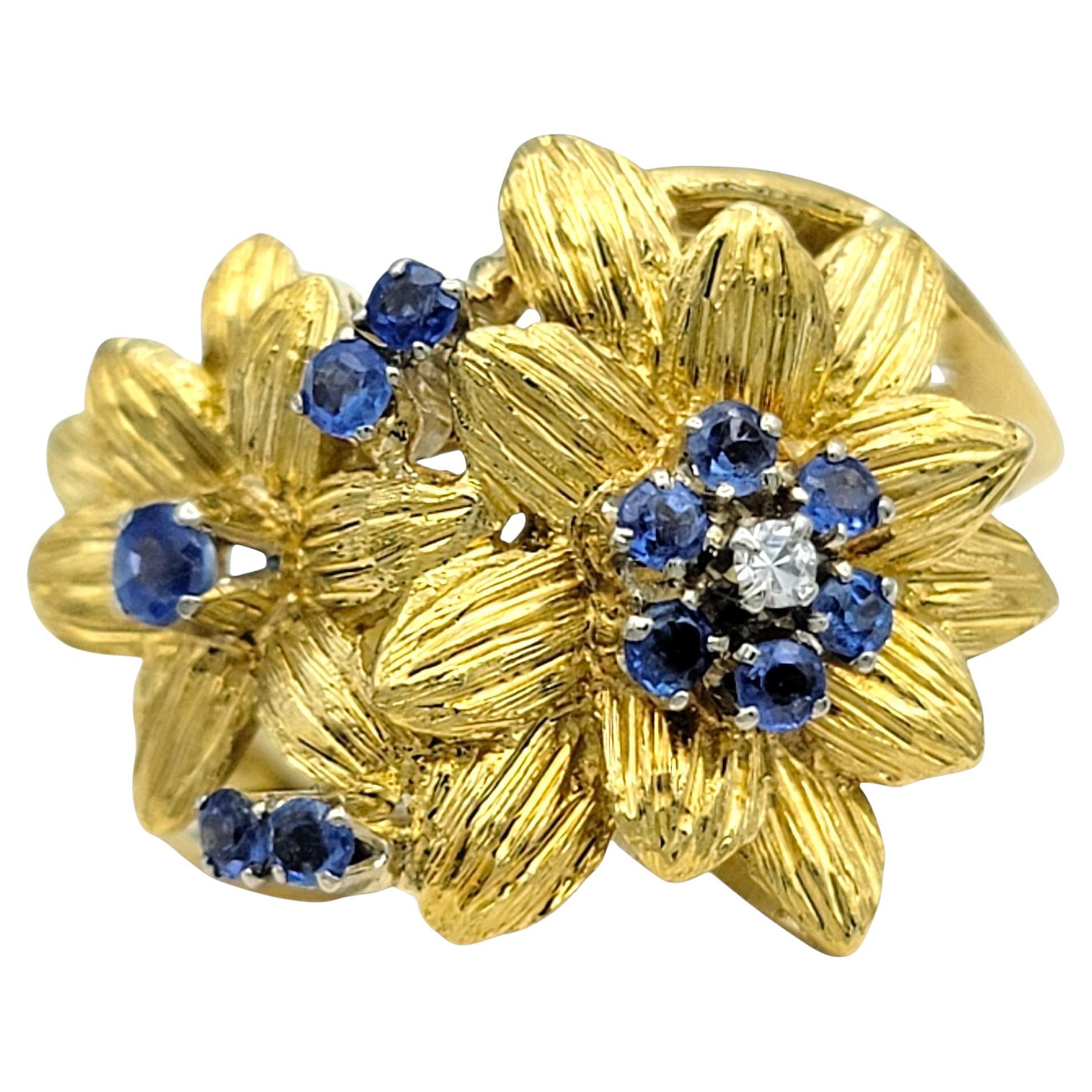 Anello con zaffiro blu rotondo e diamante con motivo floreale strutturato in oro giallo 18 carati