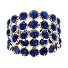 Dreifach-lagiges Band aus 18 Karat Gelbgold mit rundem blauem Saphir