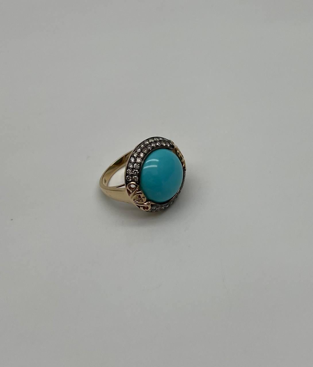 This elegant ring is crafted in a sophisticated design. It features a striking turquoise cabochon, encircled by a halo of sparkling white diamonds. The diamonds are set in a contrasting metal, enhancing their brilliance. The ring showcases intricate