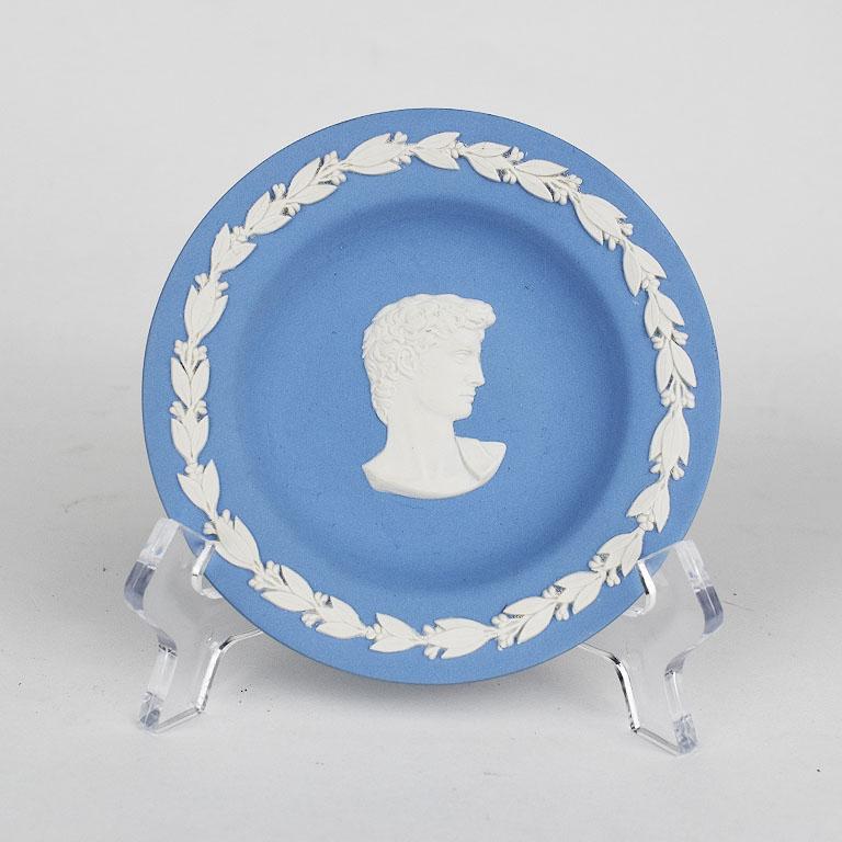 A small round light blue jaserware trinket dish by Wedgwood. The perfect finishing touch in the room of any grand milenneial. A collectible piece from The Wedgwood Collectors Society. A decorative cream vine encircles the outer rim of the dish. At