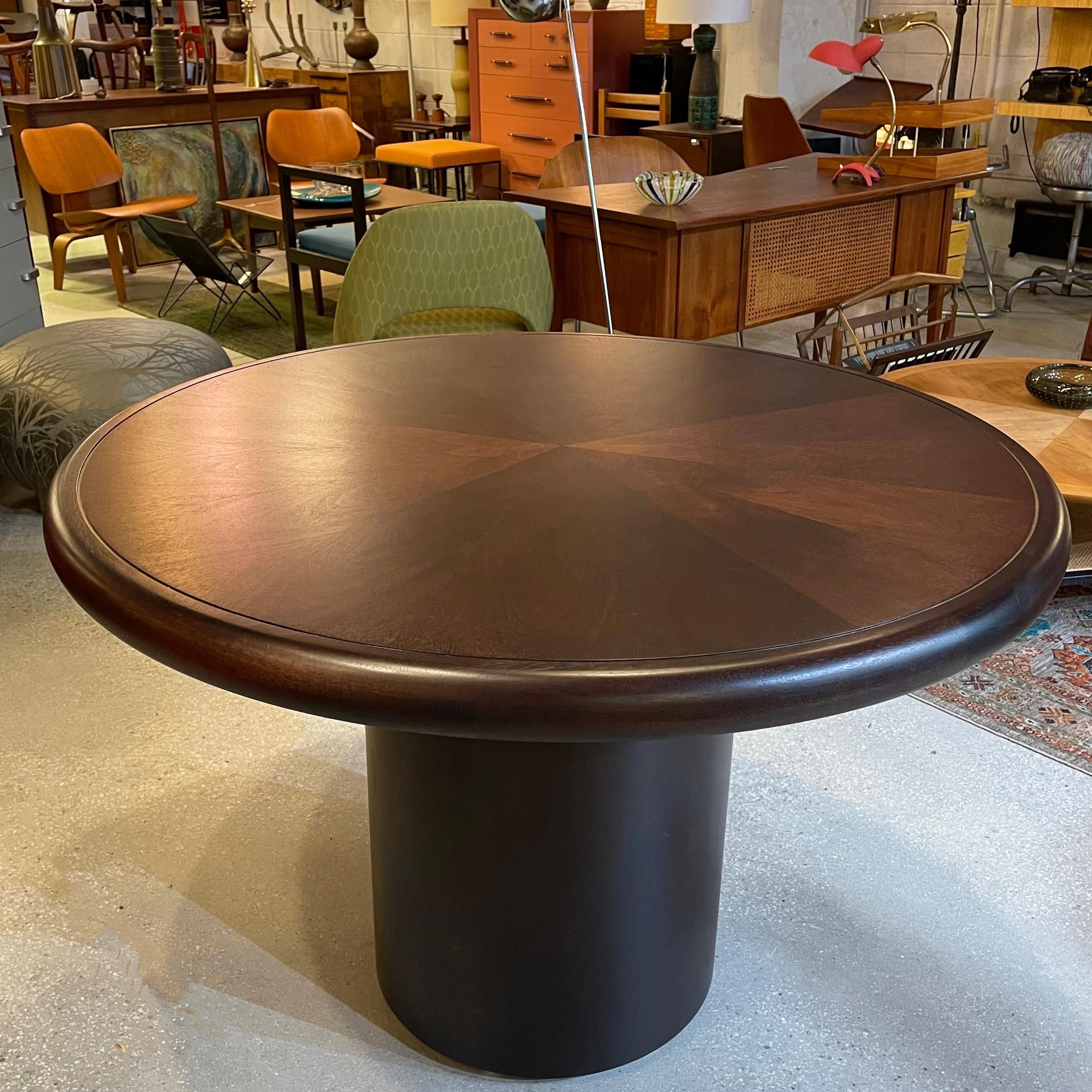 Exceptional, round, rosewood dining table by Edward Wormley for Dunbar features a 2.5 inch thick, bookmatched starburst pattern top with bullnose edge atop a substantial pedestal base. An inset brass band runs an inch inside the diameter of the