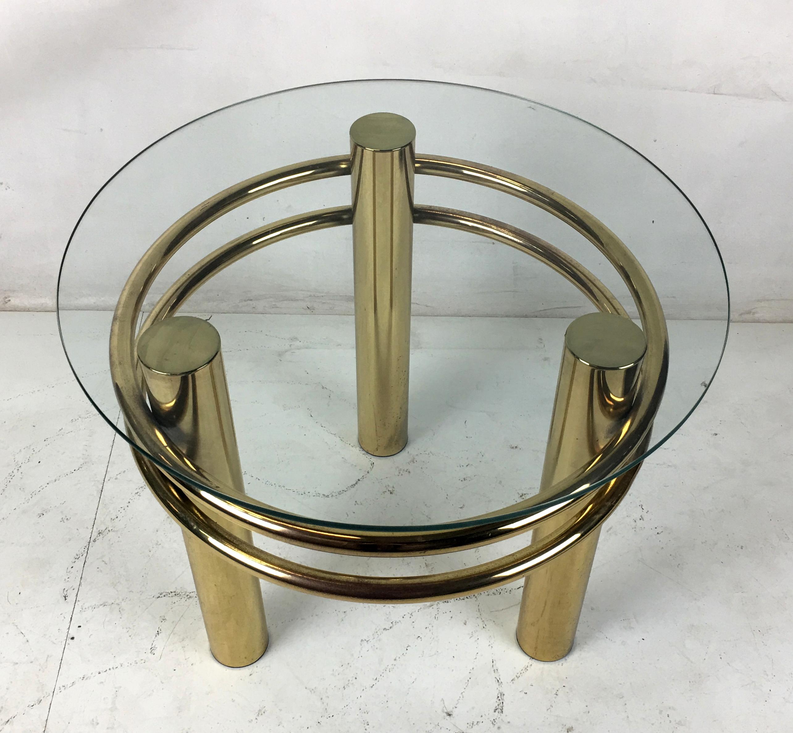 Dramatic side table with glass top in the 1980s taste with large diameter brass supports. The table goes great with its glass top or buyer-supplied marble top.