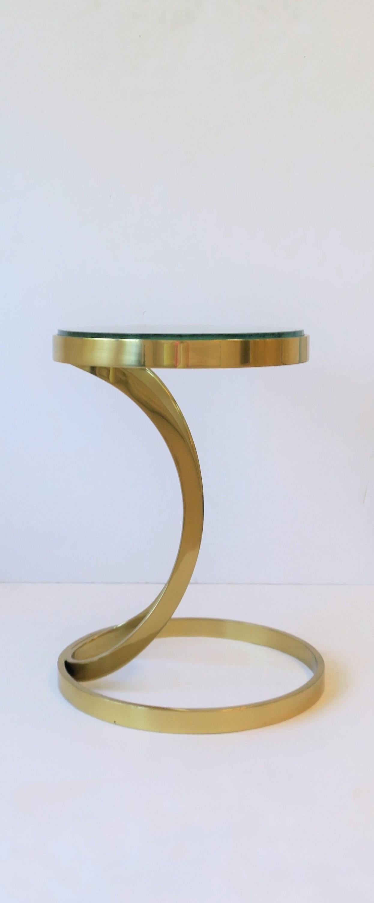 A substantial round brass and glass side/drinks table, circa early-21st century. A great table for drinks/cocktails in a convenient size. Very good condition as shown in images and video, with no chips to glass top noted. Glass top thickness