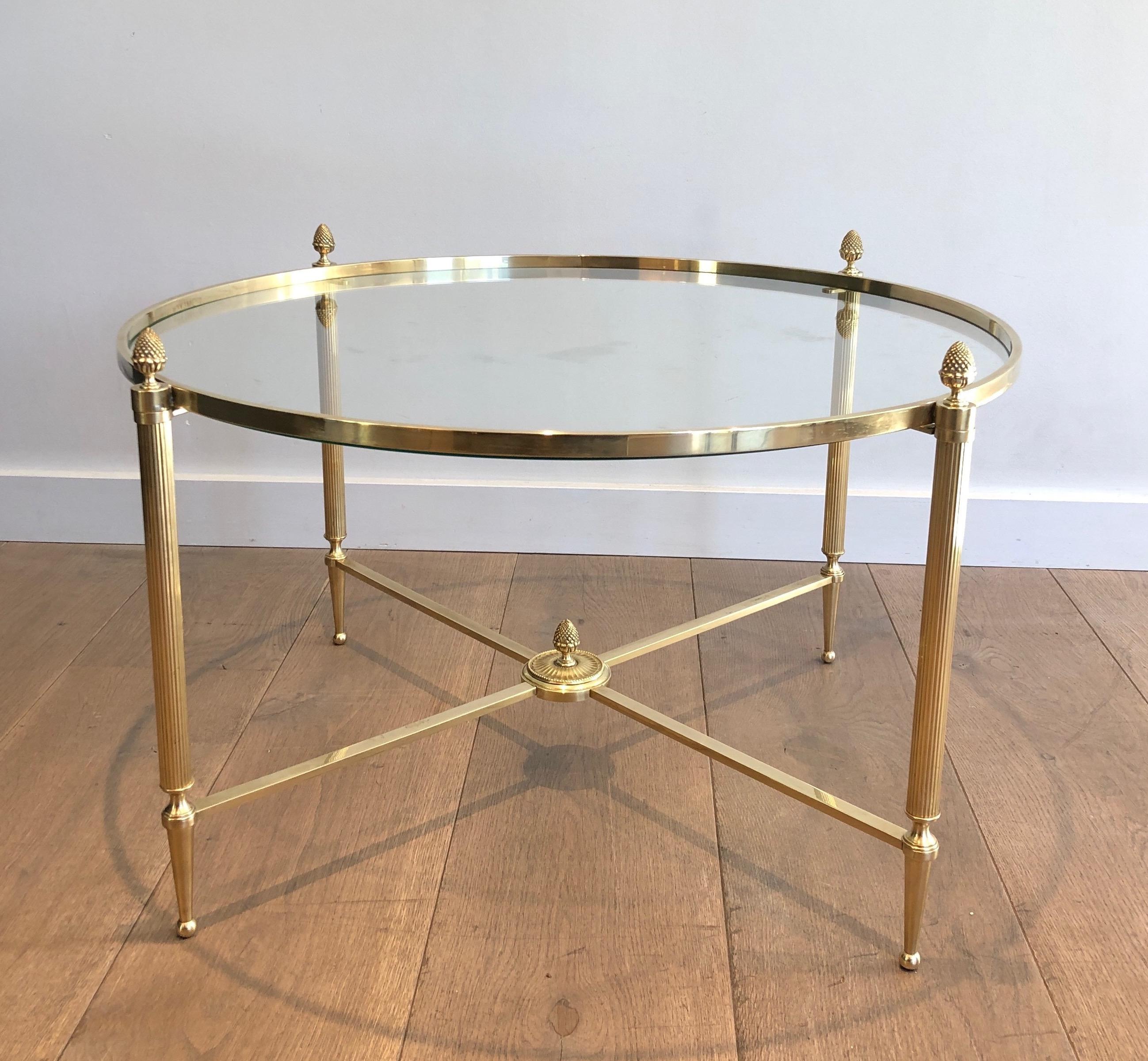 Cette table basse ronde de style néoclassique. est fabriquée en laiton avec un châssis et 4 élégants épis de faîtage en laiton. Il s'agit d'une œuvre française de la célèbre Maison Baguès. Circa 1940.
 