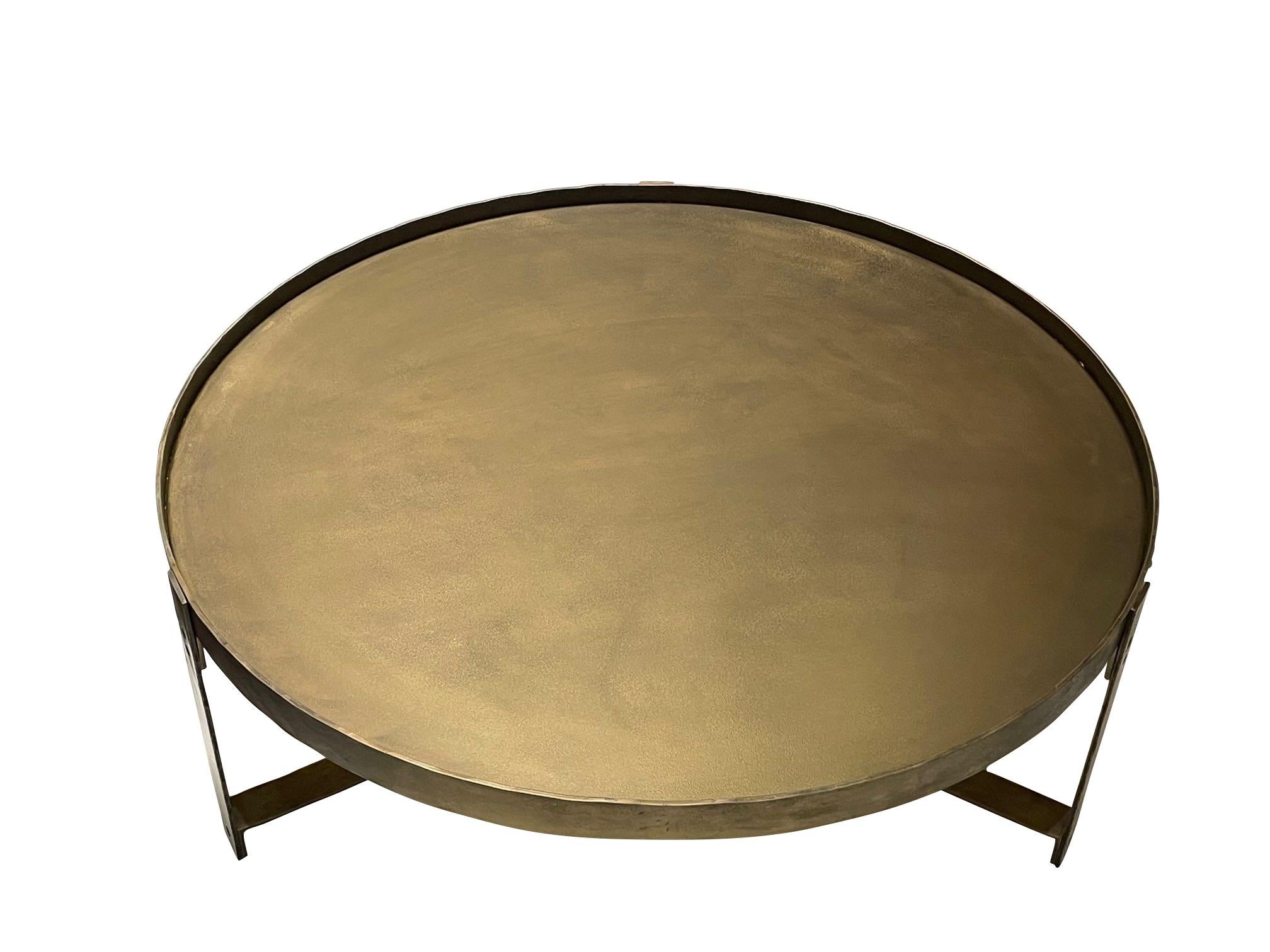 Contemporary Indian round brass coffee table with raised surrounding lip. 
Top supported by self tripod leg X stretcher base.
Also available in smaller size (F2911)
Arriving April.