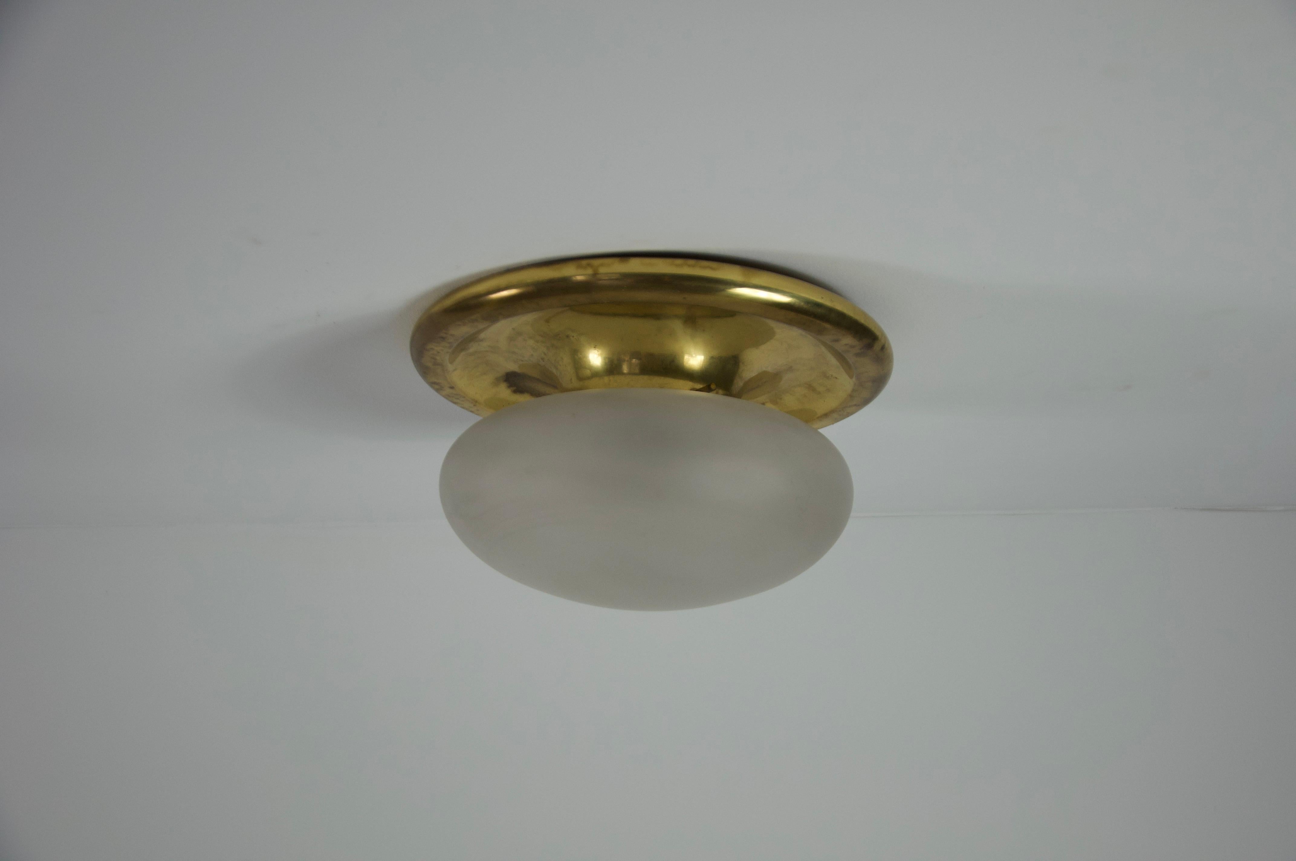 Ce luminaire encastré du milieu du siècle dernier, originaire d'Italie et datant des années 1960, est un exemple de design intemporel et d'élégance discrète. Le luminaire est doté d'une base ronde classique en laiton qui s'adapte parfaitement au
