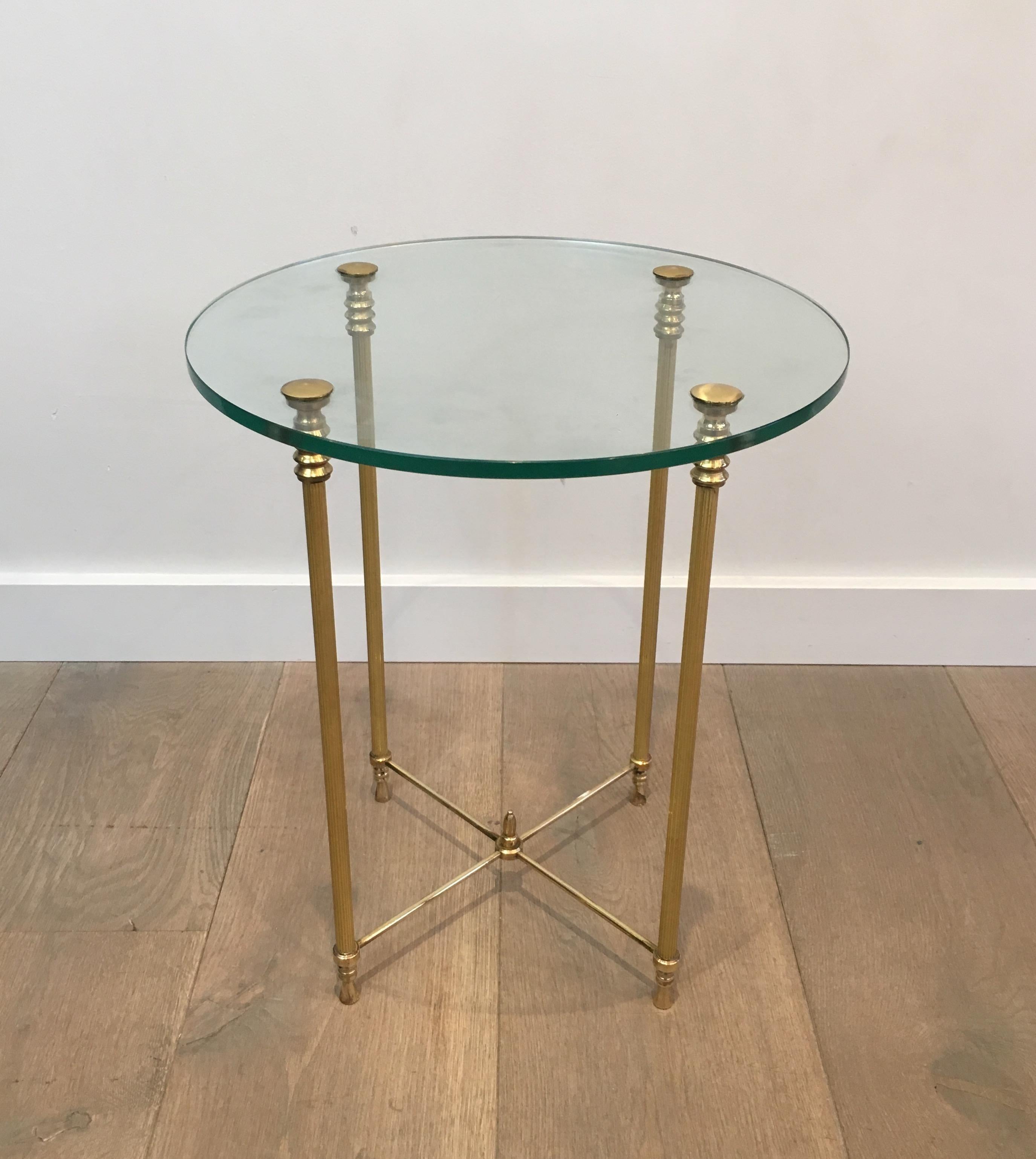 This small round side table is made of brass with a circular glass top. This is a French work, circa 1970.