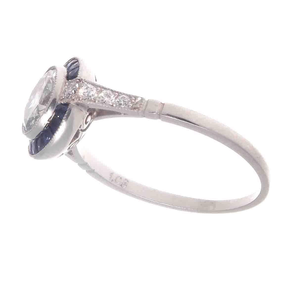 A stylish recreation from the art deco era. Featuring a brilliant  1.03 round diamond surrounded by a halo of heavenly blue sapphires. A colorful and well made ring, lovingly hand crafted in platinum.
Ring size 7 and may easily be re-sized to fit.