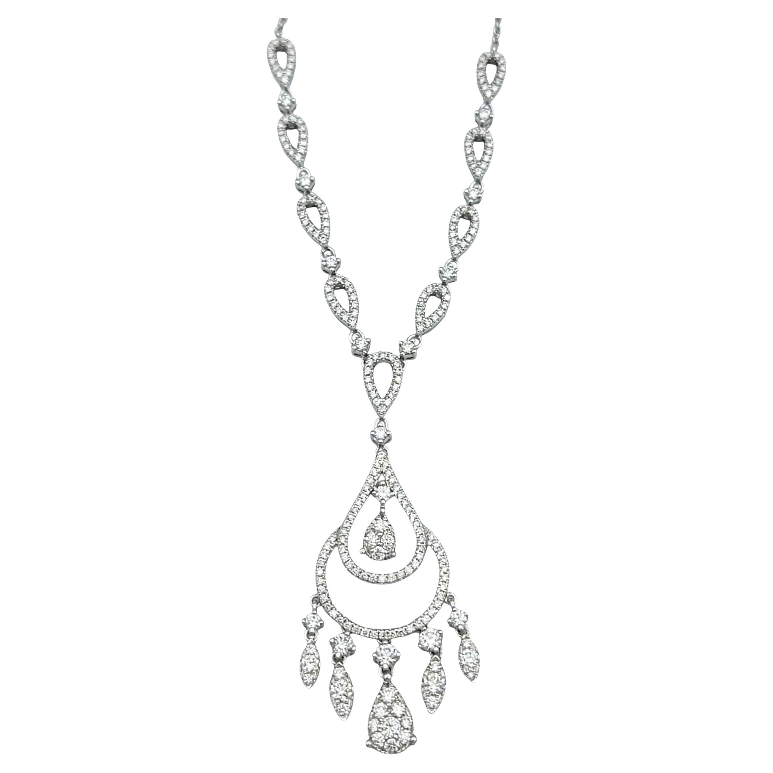 Questa lussuosa collana in stile lampadario è un pezzo da esposizione progettato per abbagliare. Realizzato in oro bianco 14 carati, presenta un'elegante cascata di anelli e gocce di diamanti, che creano un movimento aggraziato e una brillantezza