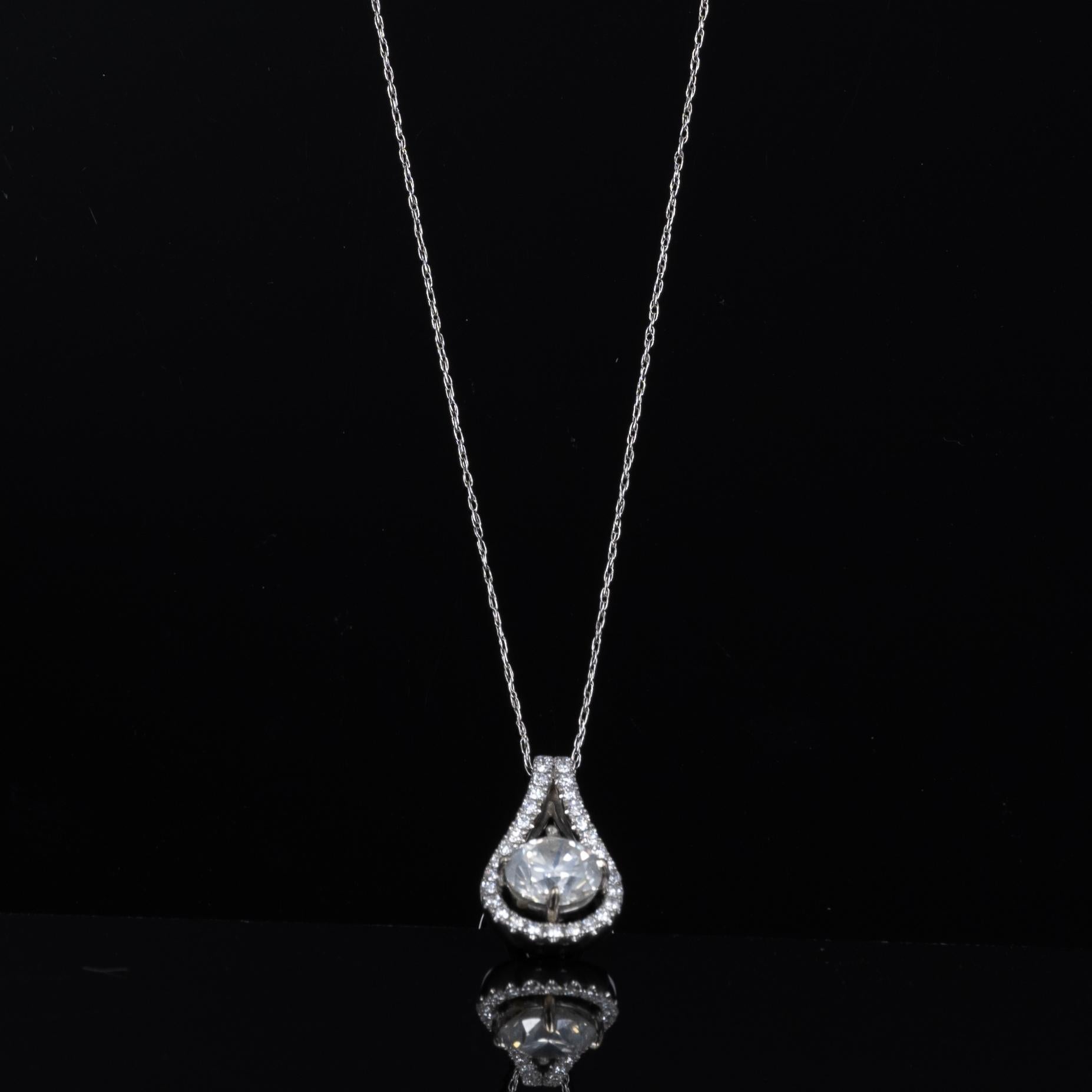 Dieses exquisite Collier zeigt einen atemberaubenden runden Diamanten von 2,0 Karat, der elegant von einem Kranz kleinerer perlenförmiger Diamanten eingerahmt wird. Die Fassung aus 14-karätigem Weißgold unterstreicht die Brillanz und das Feuer des