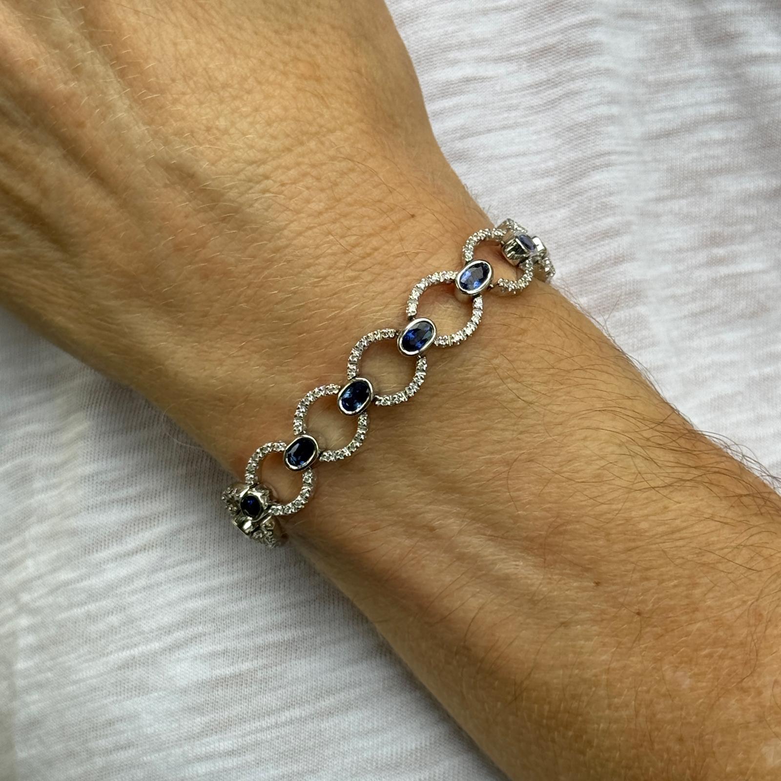 Cet élégant bracelet en or blanc 18 carats présente un motif alterné de diamants étincelants et de saphirs richement colorés. Les maillons ronds sont sertis d'environ 140 diamants ronds de taille brillant totalisant environ 0,80 carats, de couleur