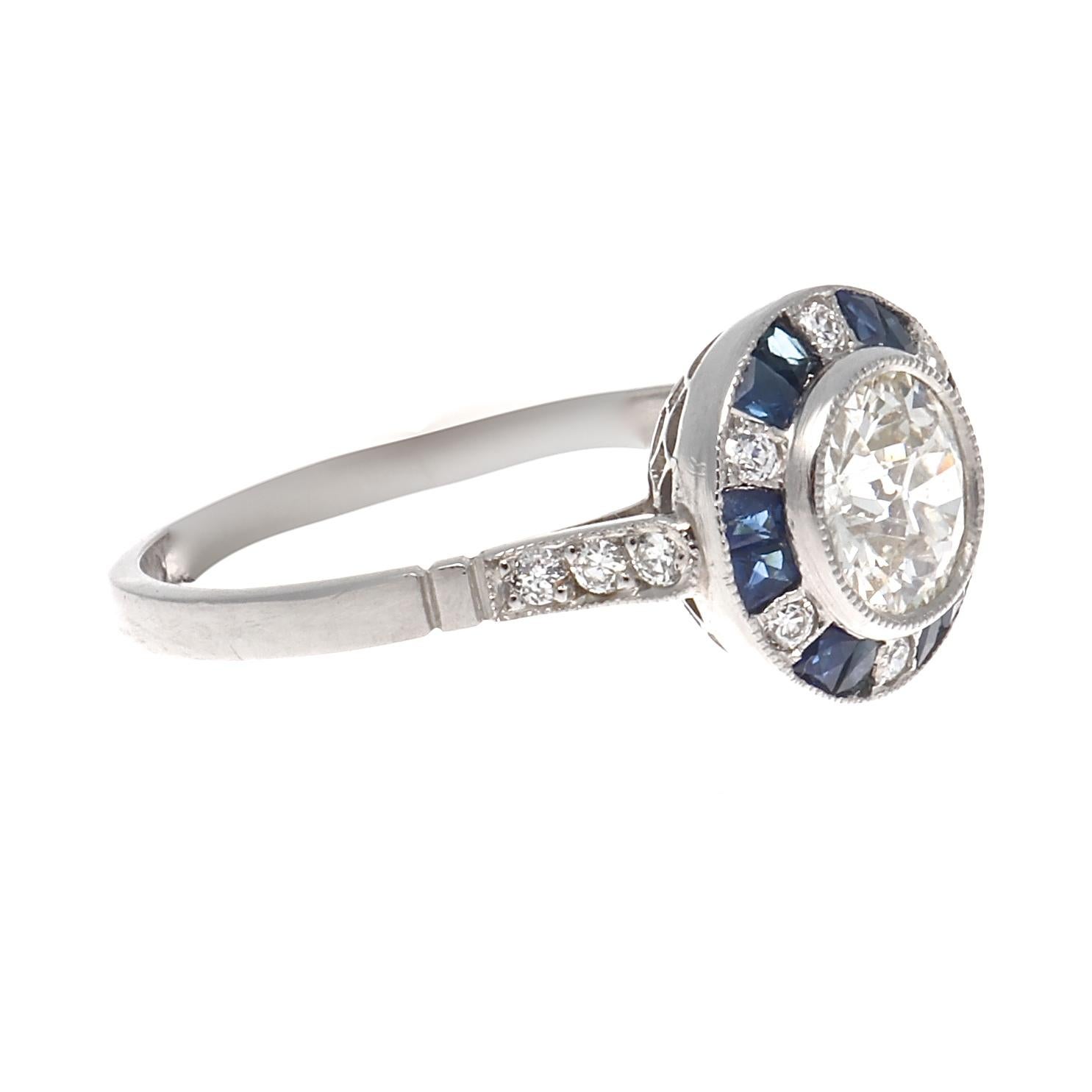 Radiating brilliance through colorful modern design. Featuring a 0.73 carat round brilliant cut diamond that is I color, VS2 clarity creatively surrounded by sectors of navy blue sapphires and diamonds. Hand crafted in platinum. Ring size 7-1/4 and