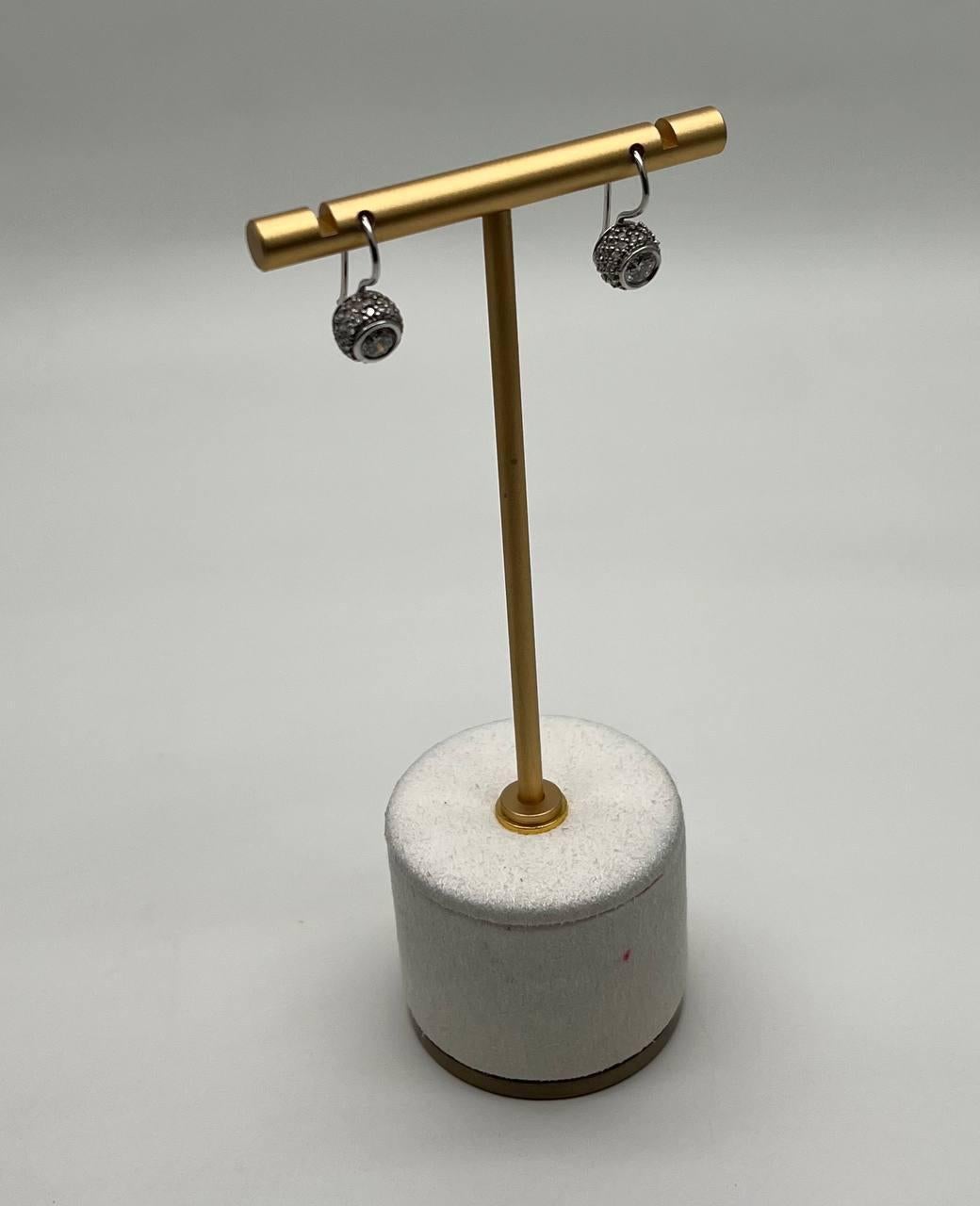 These exquisite earrings feature a spherical design with intricate detailing. The earrings are suspended from a sleek, polished hoop, allowing for subtle movement. Crafted with precision, they exhibit a refined aesthetic.
14K White Gold. 1.50 CTW