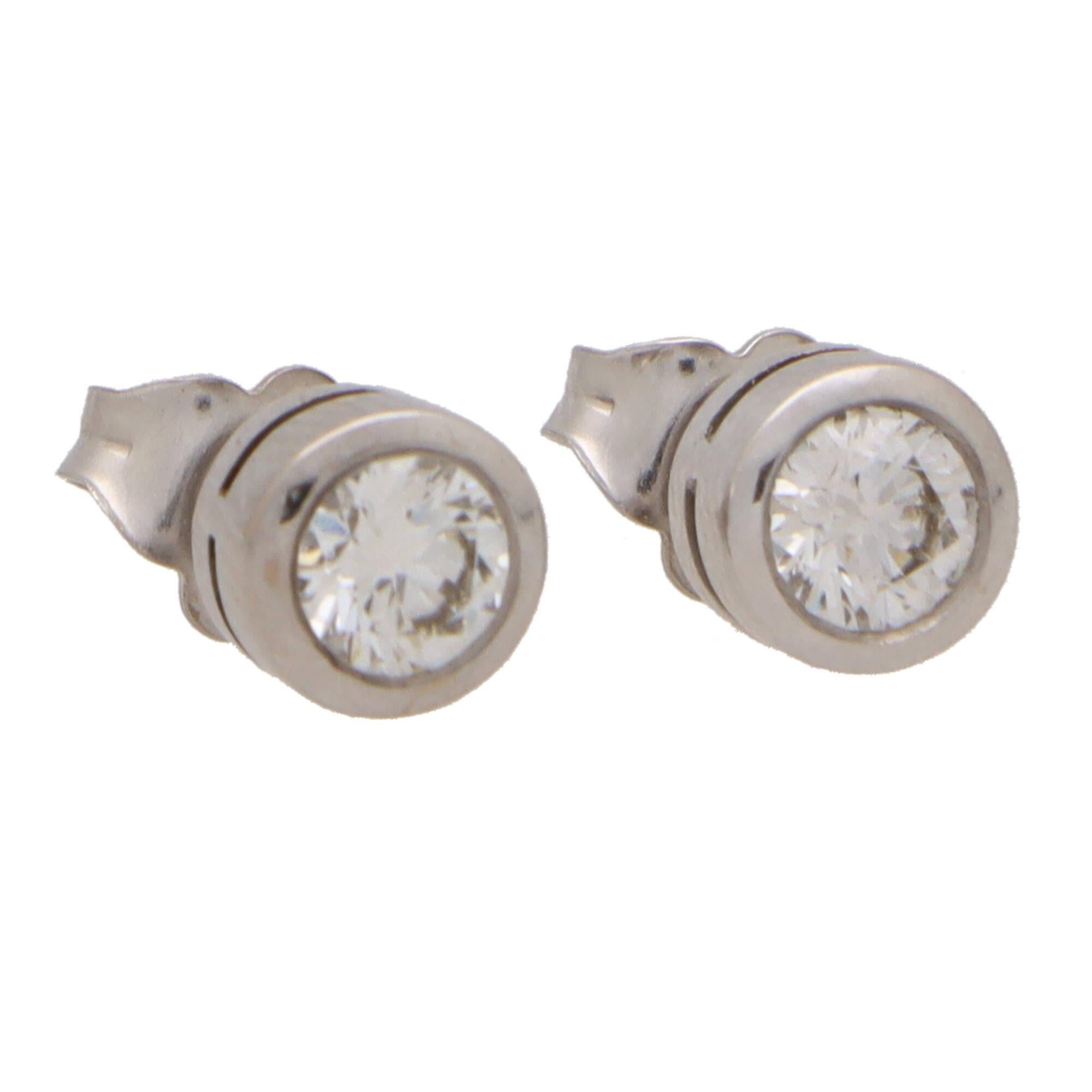  A lovely pair of round brilliant cut diamond stud earrings set in 18k white gold.

Each earring is solely set with a 0.40 carat round brilliant cut diamond which is securely set in a chunky white gold rub over setting. Both earrings are secured to