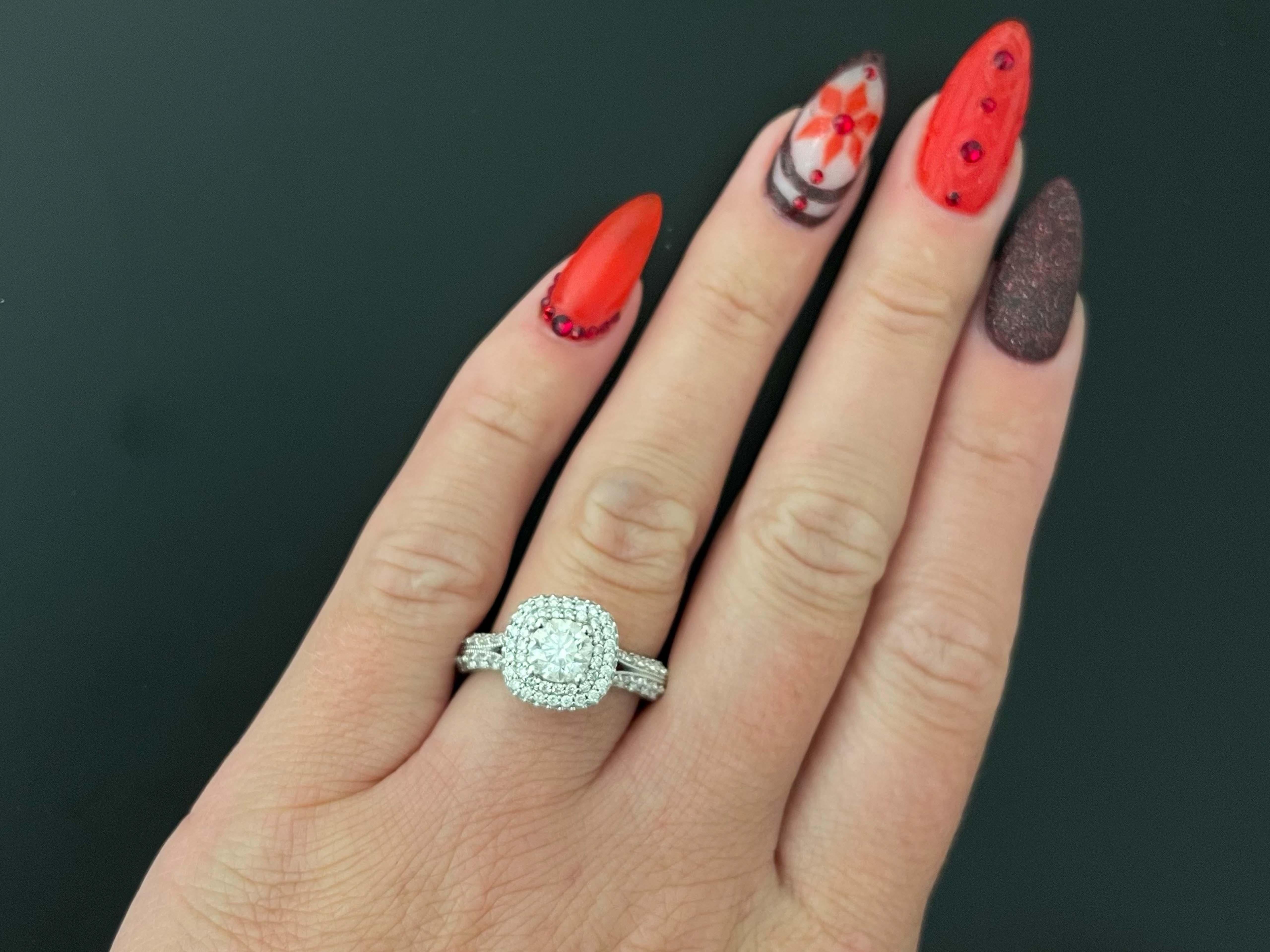 This stunning ring has a round brilliant cut 0.84 carat diamond set in 4 prongs, surrounded by a double diamond halo. The ring has a split shank set with diamonds. The center diamond is H-I in color and SI2 in clarity. The additional 132 diamonds