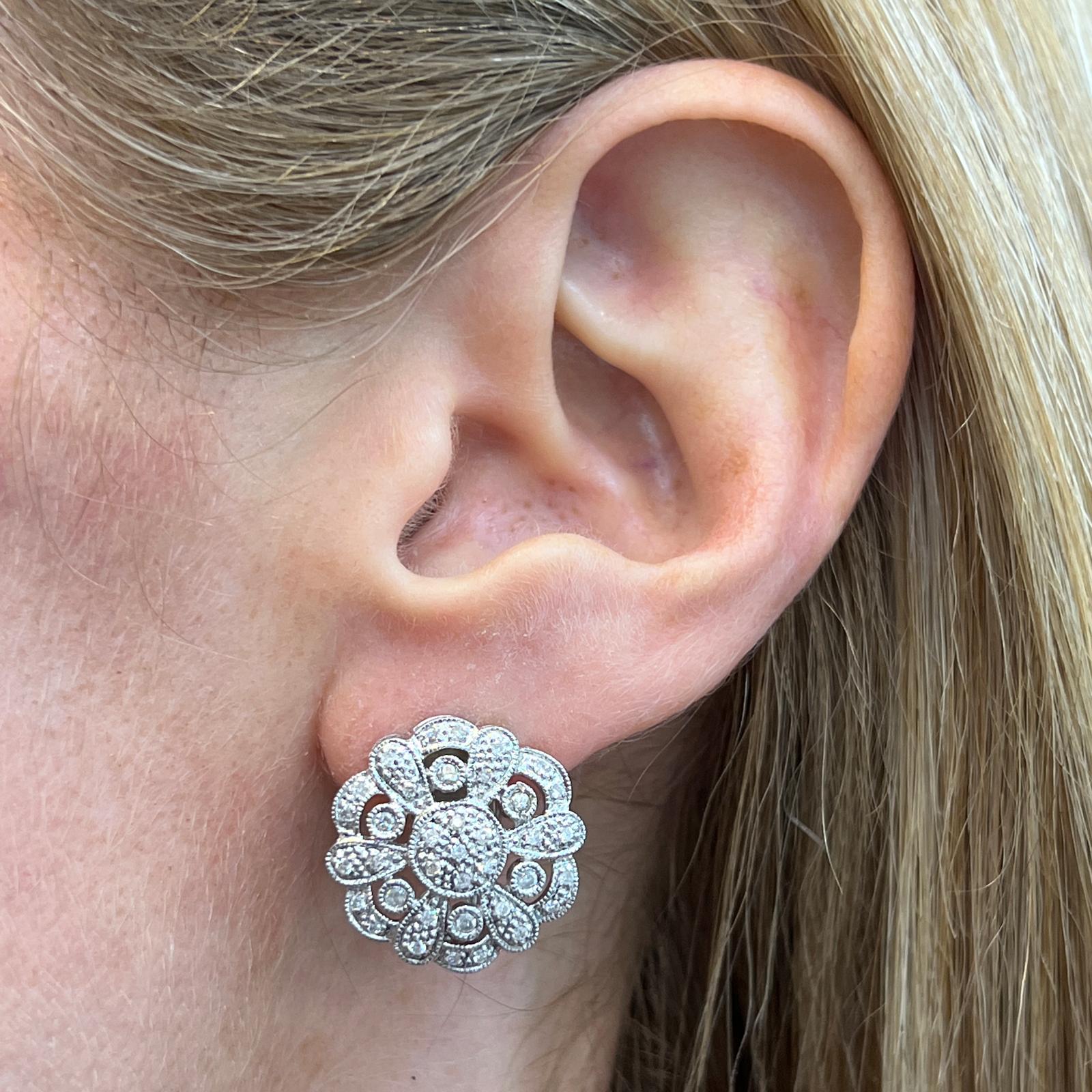 Circular diamond earrings fashioned in 14 karat white gold. The earrings feature 72 round brilliant cut diamonds weighing approximately 1.00 CTW and graded H-I color and SI clarity. The earrings measure .75 x .75 inches, and are light enough for