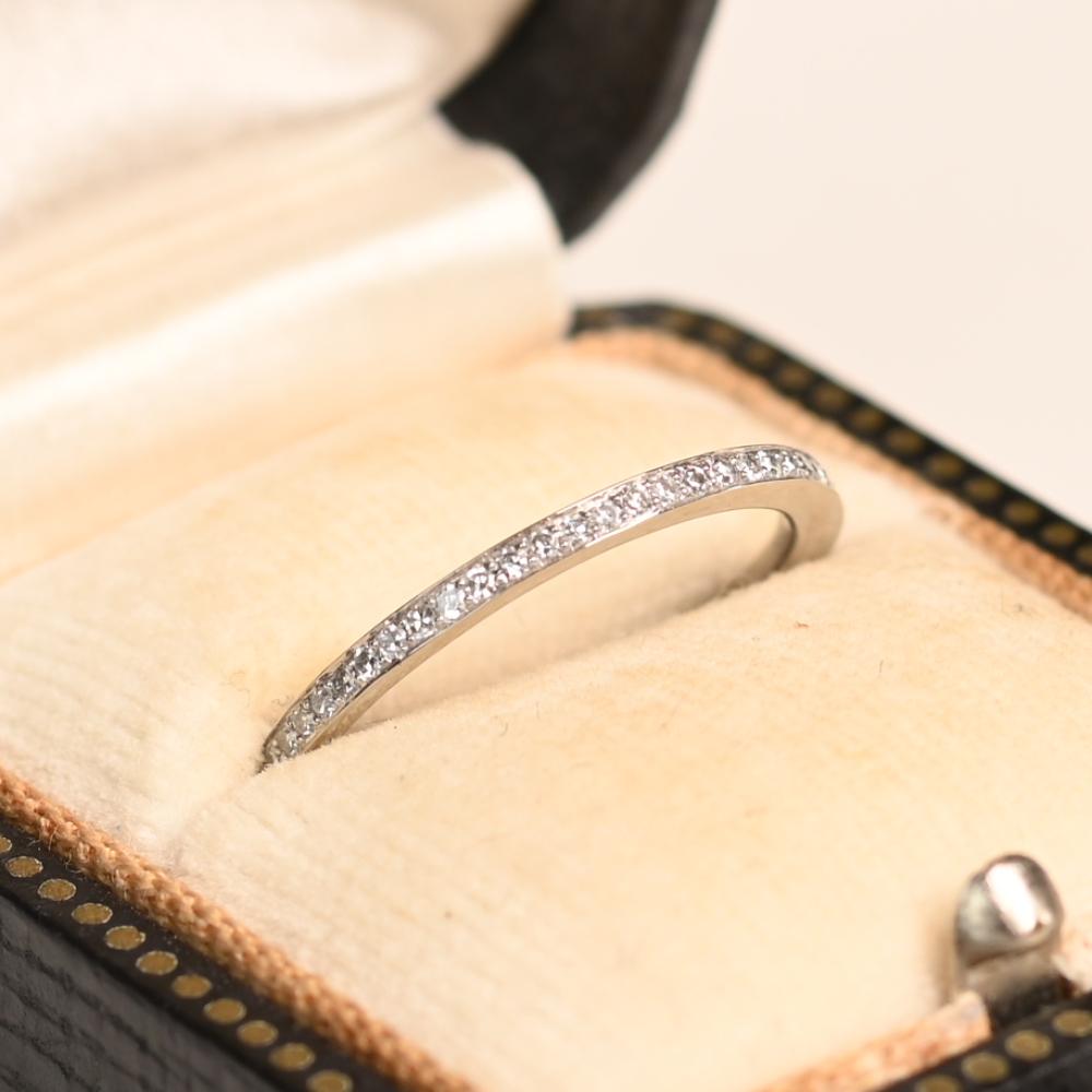 Esta exquisita alianza de eternidad es un verdadero testimonio de elegancia atemporal y artesanía. Con una hilera sin fisuras de micropavé de diamantes redondos talla brillante, la banda brilla con un resplandor radiante y uniforme. El meticuloso