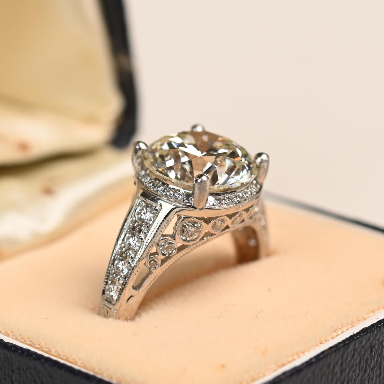 Questo squisito anello in platino ospita un diamante certificato GIA del peso di circa 4,00 carati. Il diamante ha una gradazione di colore L e una purezza VS1, con un'impressionante brillantezza e luminosità. Un'aureola nascosta di diamanti