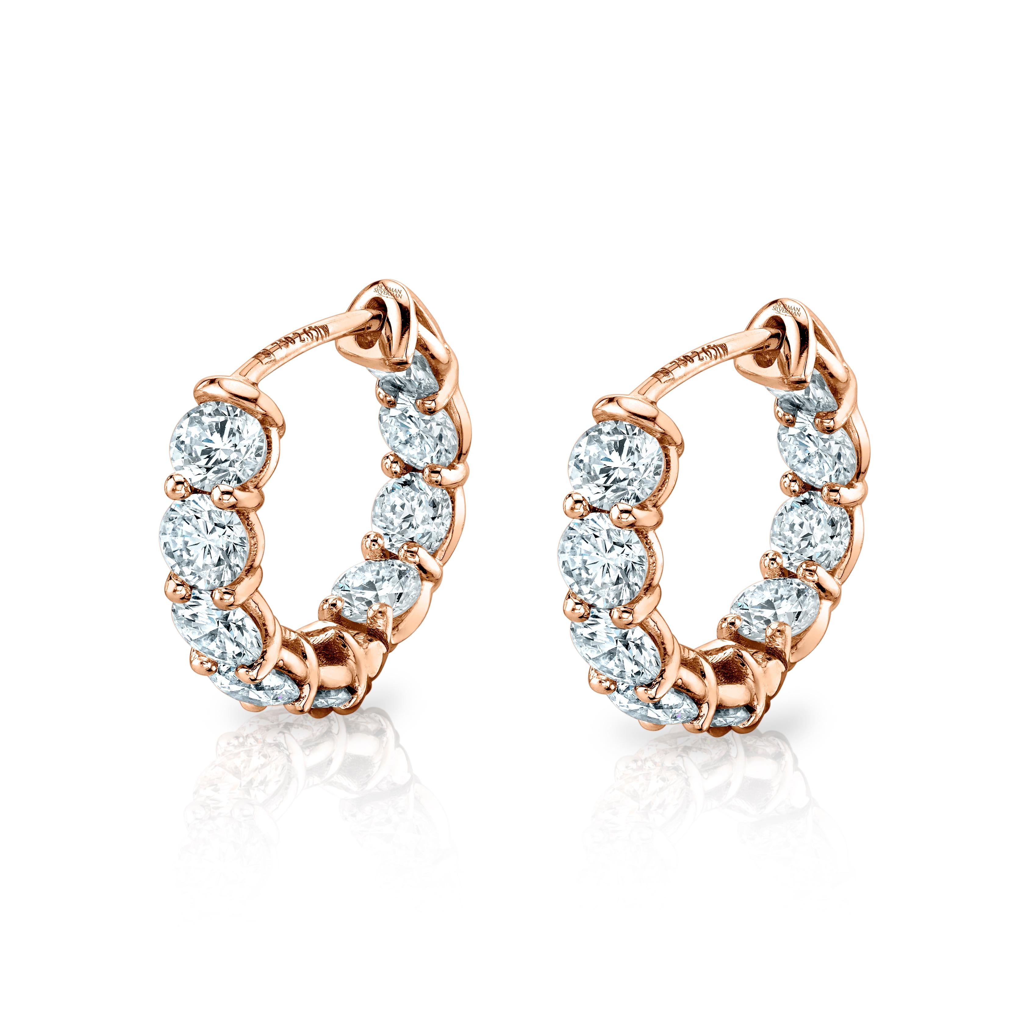 Estos pendientes de aro abrazador de adentro hacia afuera presentan 2,57 quilates de diamantes de talla ovalada -18 piedras en total- engastados en oro blanco de 18 quilates. De color G-H y claridad VS-VVS, cada diamante se engasta a mano y se