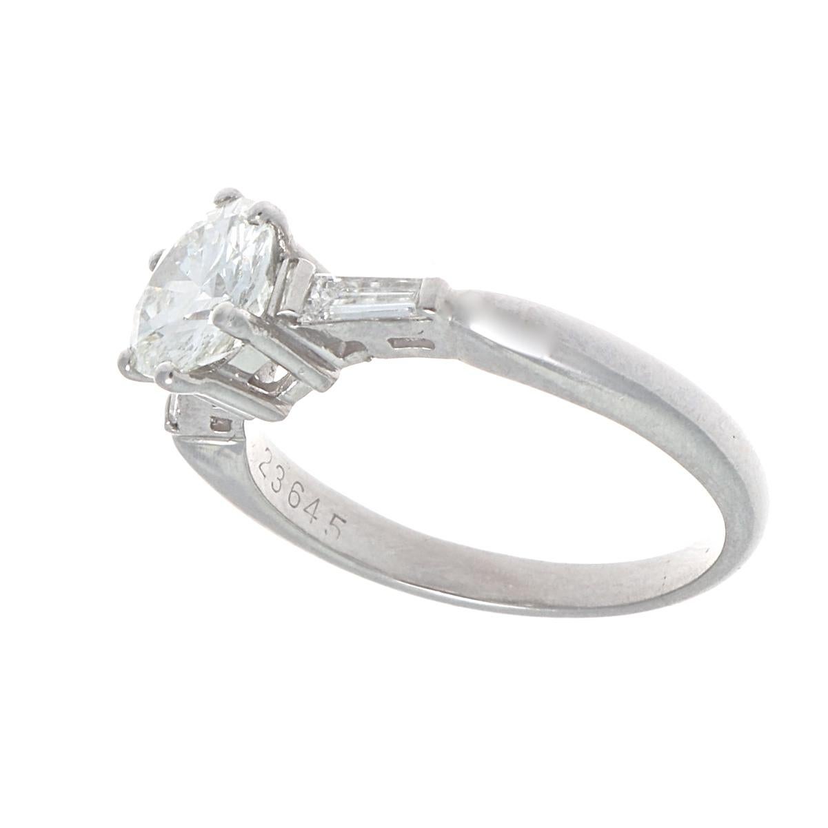 The perfect way to say I love you. Featuring a 0.76 carat round brilliant cut diamond approximately G color, VS1 clarity. Accented on either side by a single colorless baguette cut diamond. Crafted in platinum. Ring size 3-3/4 and can easily be
