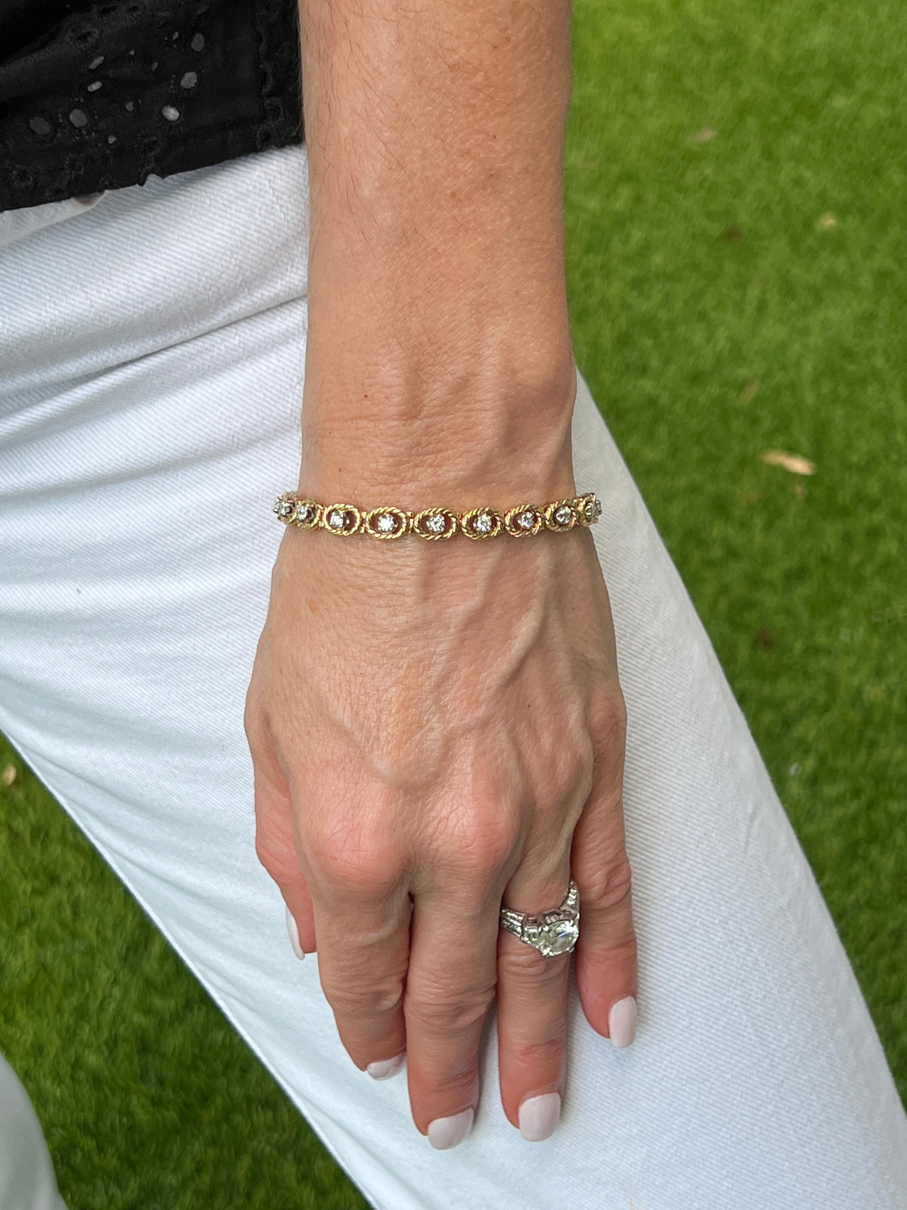 Diamond line bracelet fashioned in 14 karat yellow gold. The 18 round brilliant cut diamonds weigh approximately 1.00 CTW and are graded G-H color and VS2-SI1 color. The diamonds are surrounded by a thin gold rope design and the bracelet measures 7