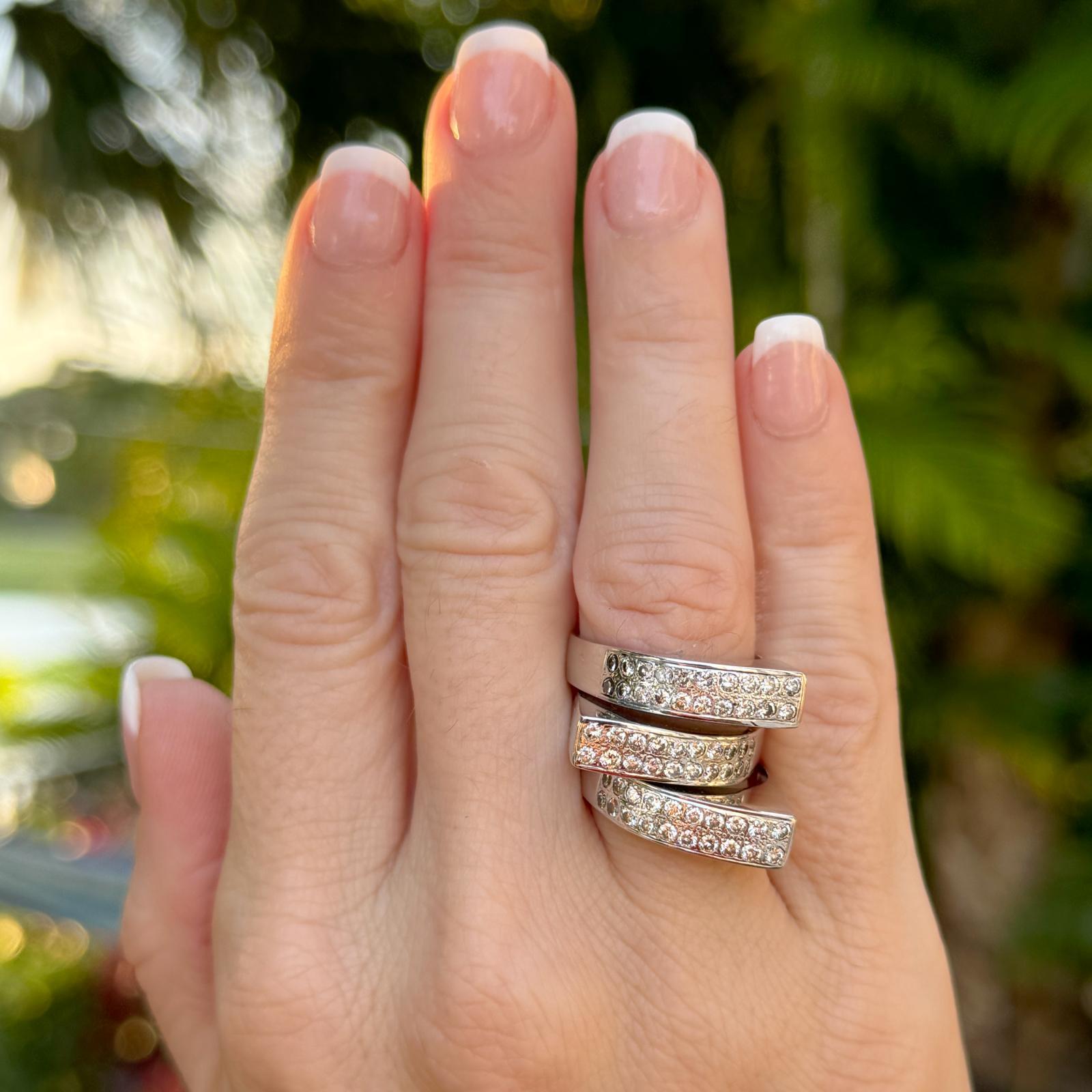 Set of three asymmetrical diamond stacking band crafted in 14 karat white gold. The ring feature 60 round brilliant cut diamonds weighing approximately 1.20 carat total weight. The diamonds are graded H-I color and SI clarity. Each ring measures