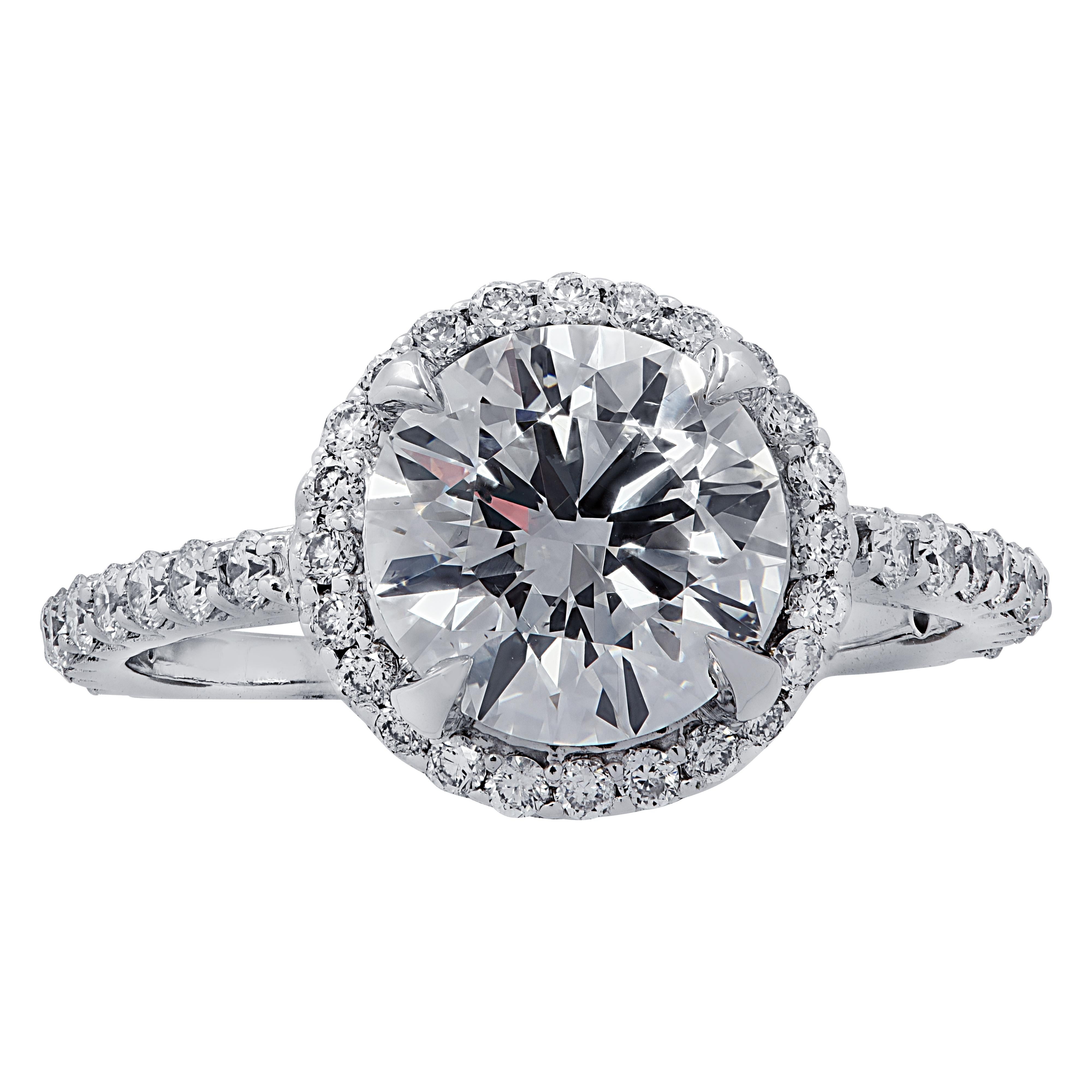 Stunning diamond halo engagement ring crafted in white gold. The ring features an 1.74 carat round brilliant cut diamond graded E color and SI1 clarity by the GIA. The center diamond is accented by 42 round brilliant cut diamonds weighing .50  carat