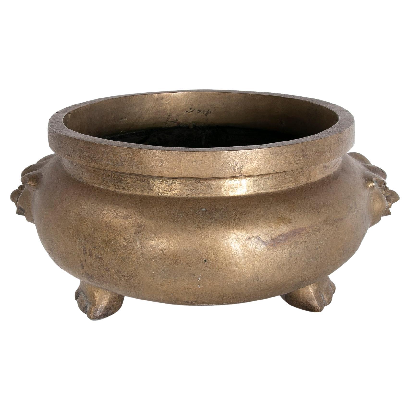 Rundes Bronzegefäß mit zweiseitiger Dekoration und fußförmigen Füßen im Angebot