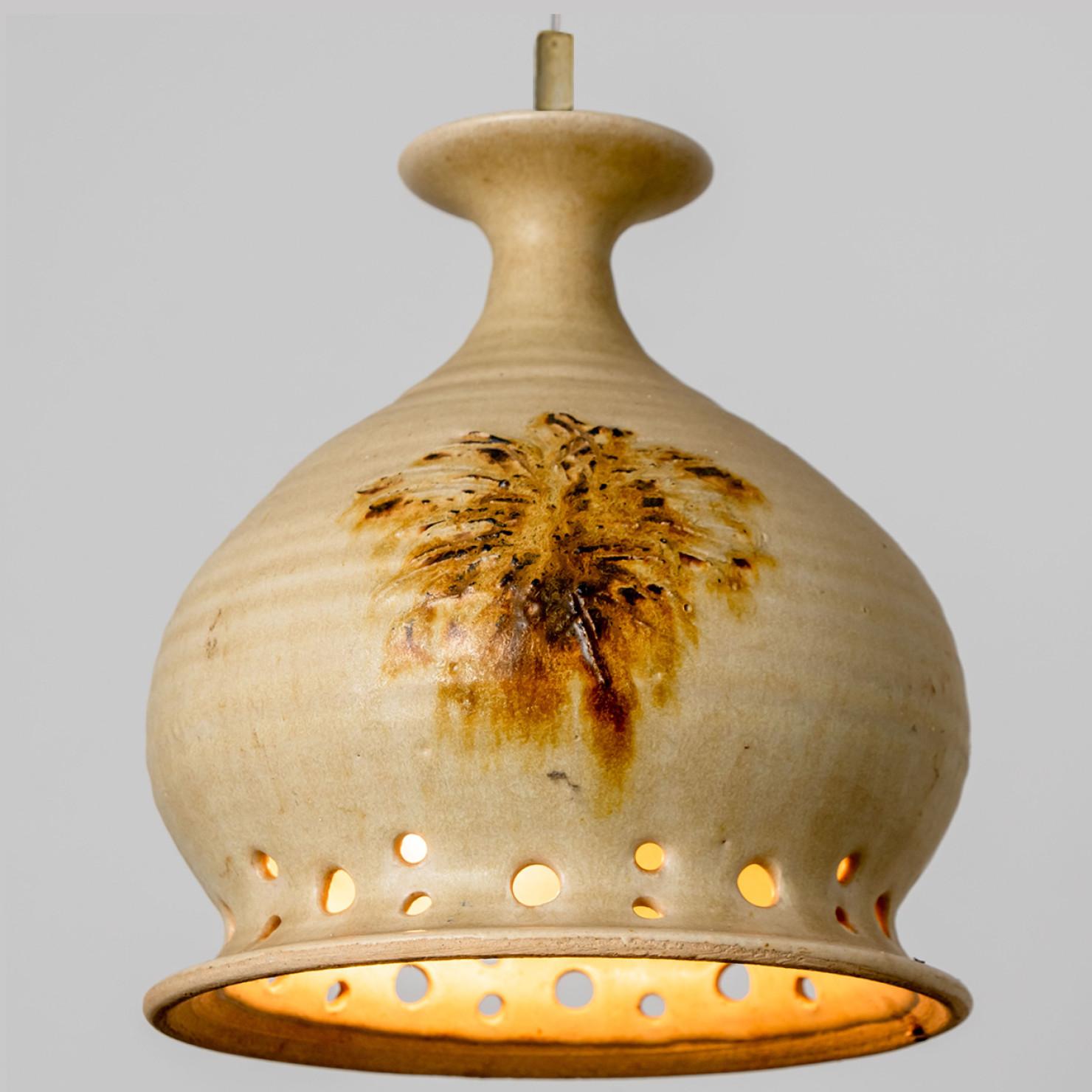 Wunderschöne runde Hängelampe mit einer ungewöhnlichen Form, hergestellt aus reichlich terrafarbener brauner Keramik, hergestellt in den 1970er Jahren in Dänemark. Wir haben auch eine Vielzahl von einzigartigen farbigen Keramik-Licht-Sets und