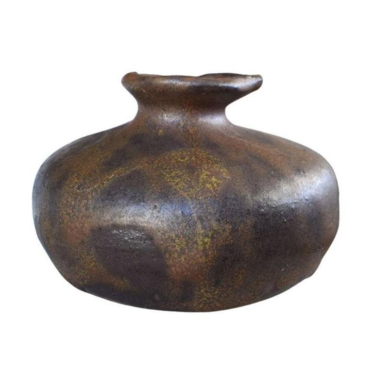 Glazed in an almost metallic-looking paint, this petite round vase will be fabulous on a nightstand, bookshelf, or side table. Studio Pottery is a favorite of ours, as no two pieces are ever the same. This piece has an unusual rim, with uneven