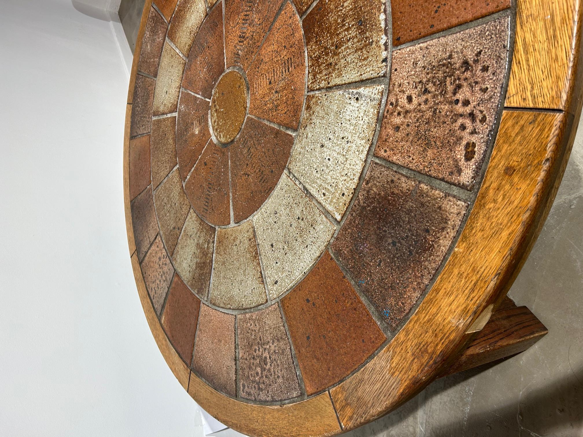 Jolie table basse ronde avec plateau en céramique et structure en bois.