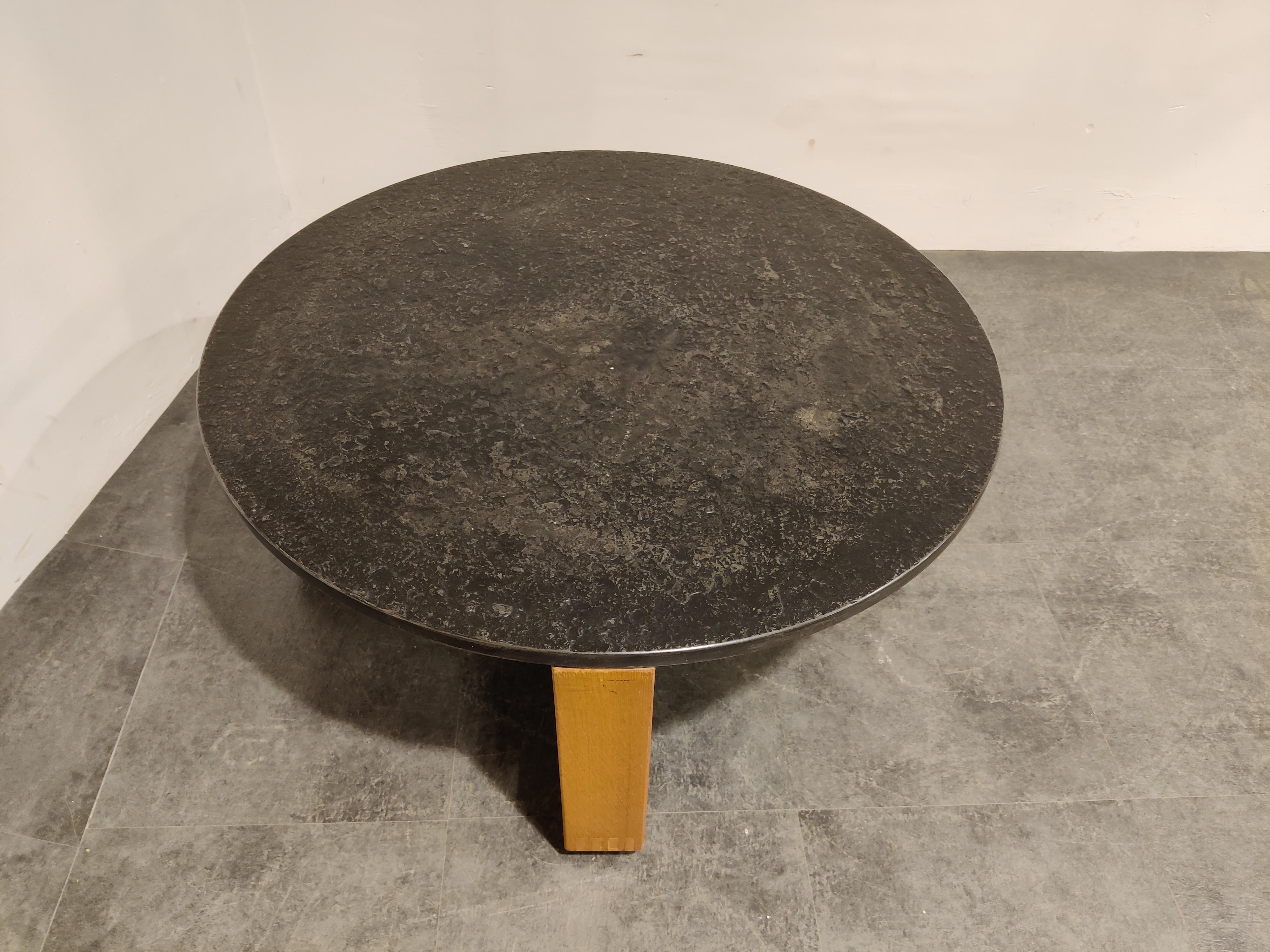 Brutalist style coffee table with a nice interlocking wooden frame and a round slate stone top. 

Stamped underneath, but no manufacturer/designer could be linked.

Made in Germany around the mid 1960s

Good condition.

Dimensions:
Height:
