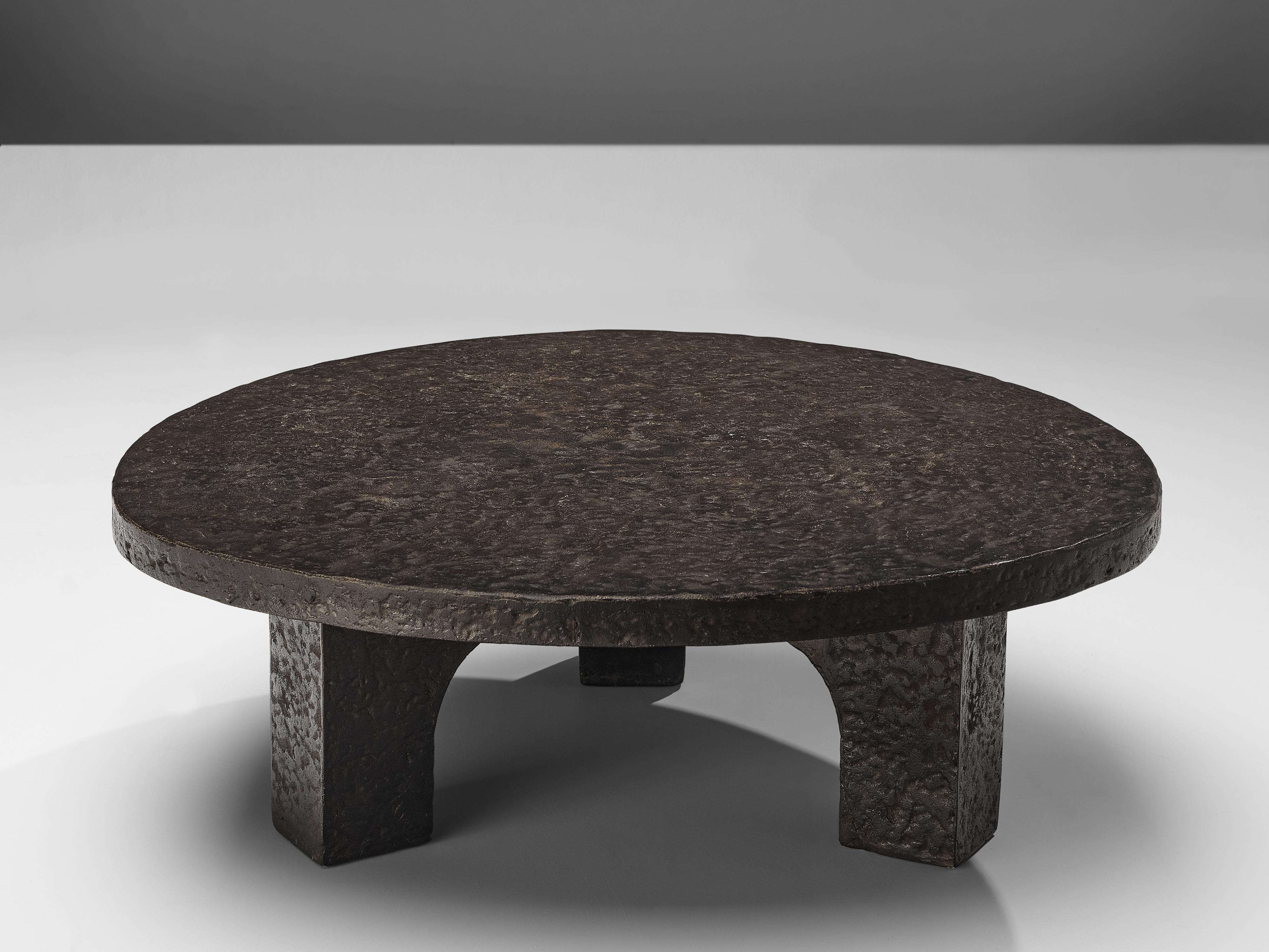 Coffee table, resin, Northern-Europe, 1970s

This deep black to brown coffee or cocktail table was made in the 1970s. The thick round top is supported by three arched legs that contribute to the sturdy, architectural appearance. This low table is