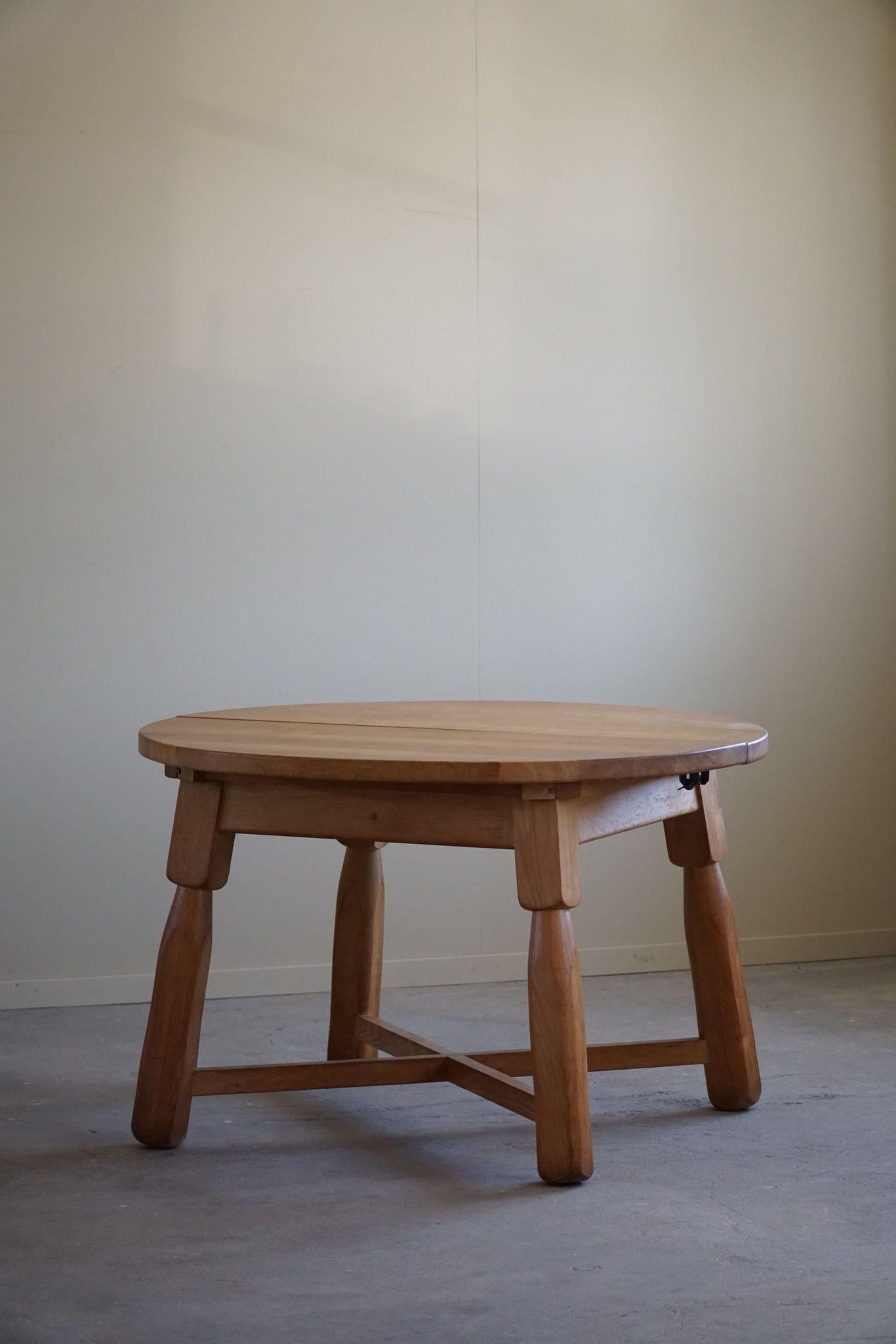 A stunning solid oak round dining table in the brutalist style, crafted in France during the 1960s by a French cabinetmaker. This mid-century modern piece features a robust and minimalist design with some nice chunky club legs.
The natural grain of