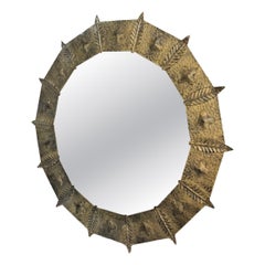 Round Brutalist mirror in hammered gold-tone metal