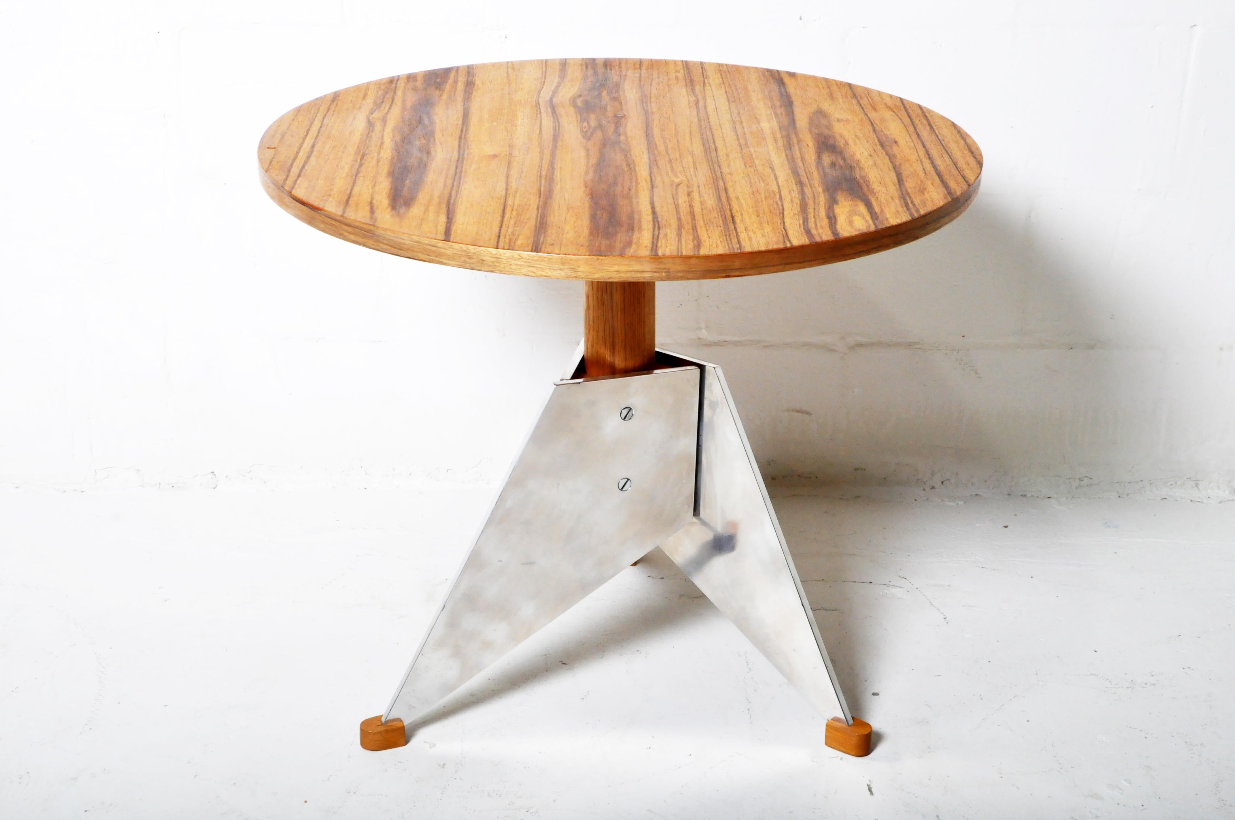 This light walnut veneer round table features an angular chromed steel base. The table is an example of brutalist 