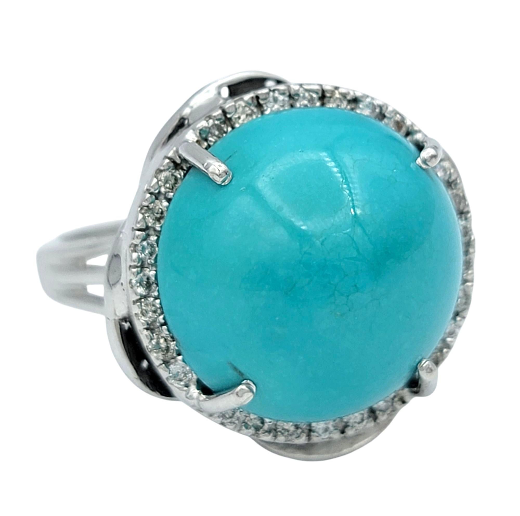 Ring Size: 7

A striking fusion of color and brilliance, this exquisite ring features a captivating round cabochon-cut turquoise in a rich teal blue hue. The smooth, domed surface of the turquoise exudes a natural vibrancy, making it a standout