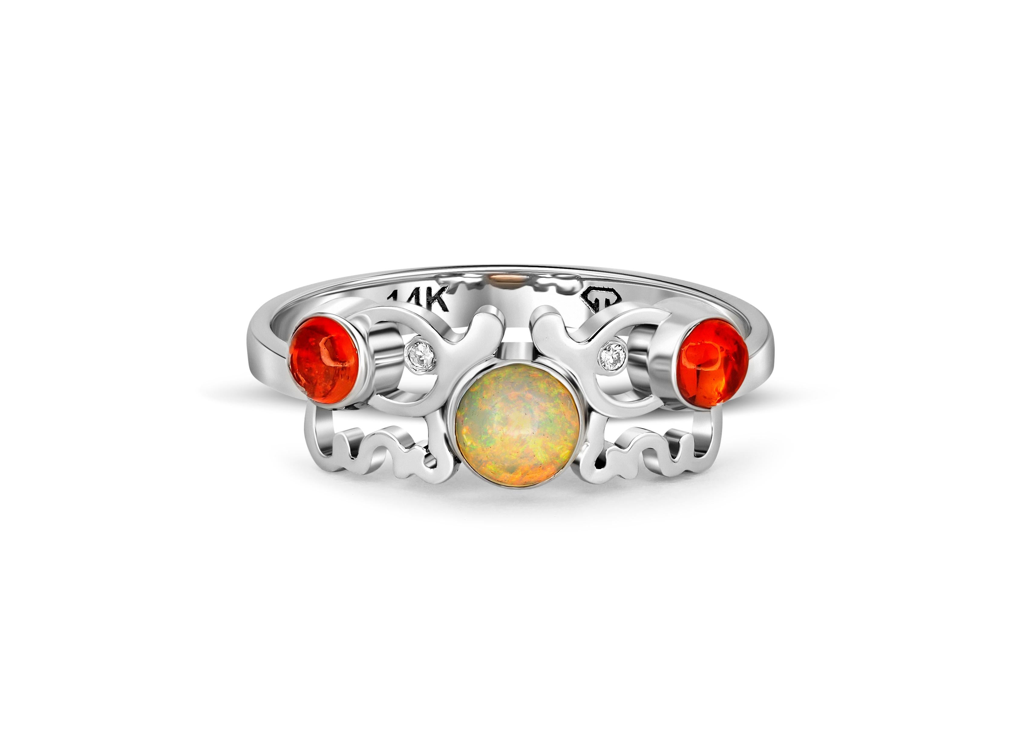 Round cabochon opal ring in 14k gold. 
Elephant gold ring. Earth on elephant ring. Animal gold ring. Dainty opal ring. Multicolor opal ring.

This mesmerizing ring features two intricately sculpted elephants that come together to hold the glimmering