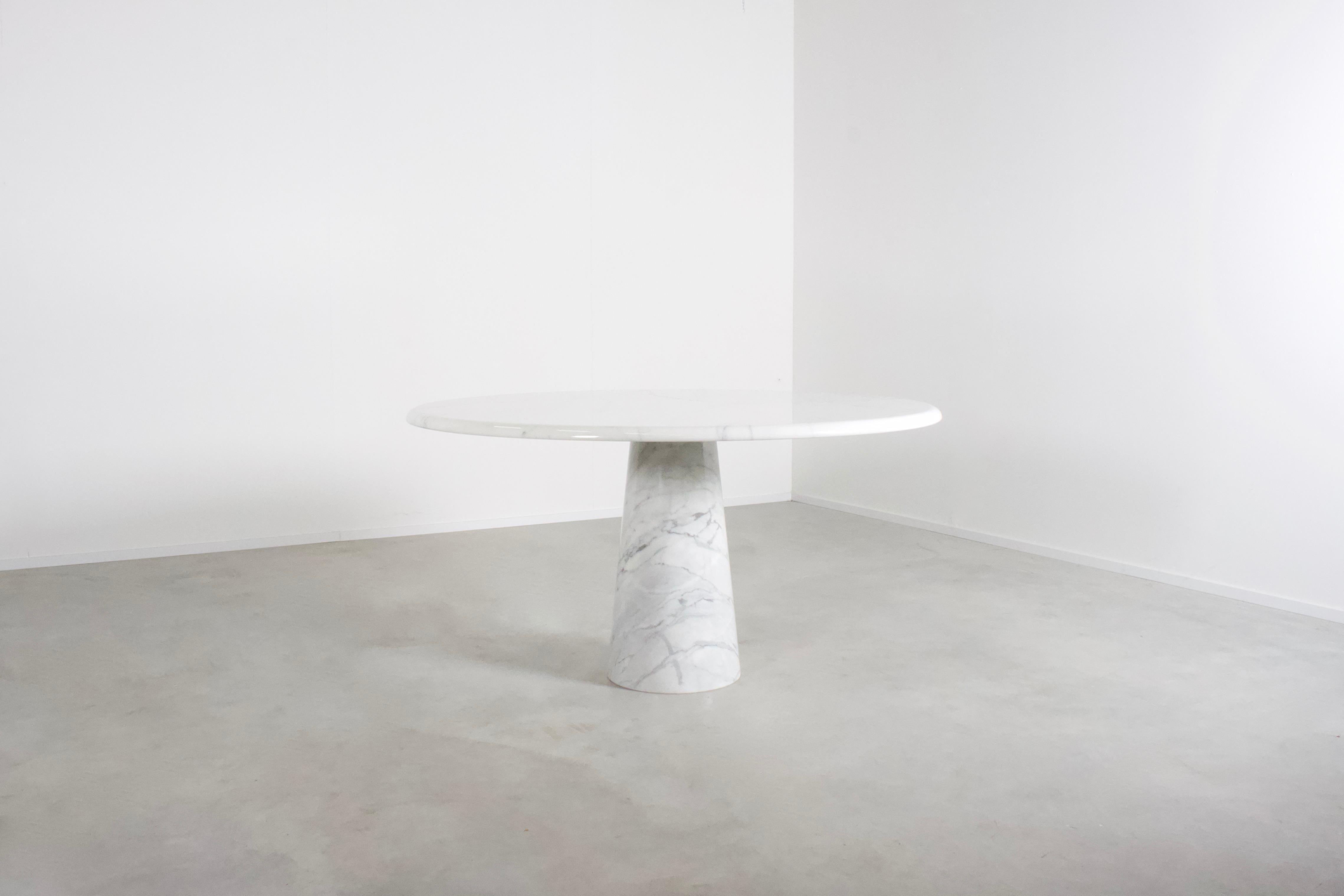 Round marble pedestal table in the manner of Angelo Mangiarotti in very good condition.

The table is made of solid Carrara marble. 

The top rests on a unique cone-shaped pedestal base also in Carrara marble. 
It balances perfectly and securely by