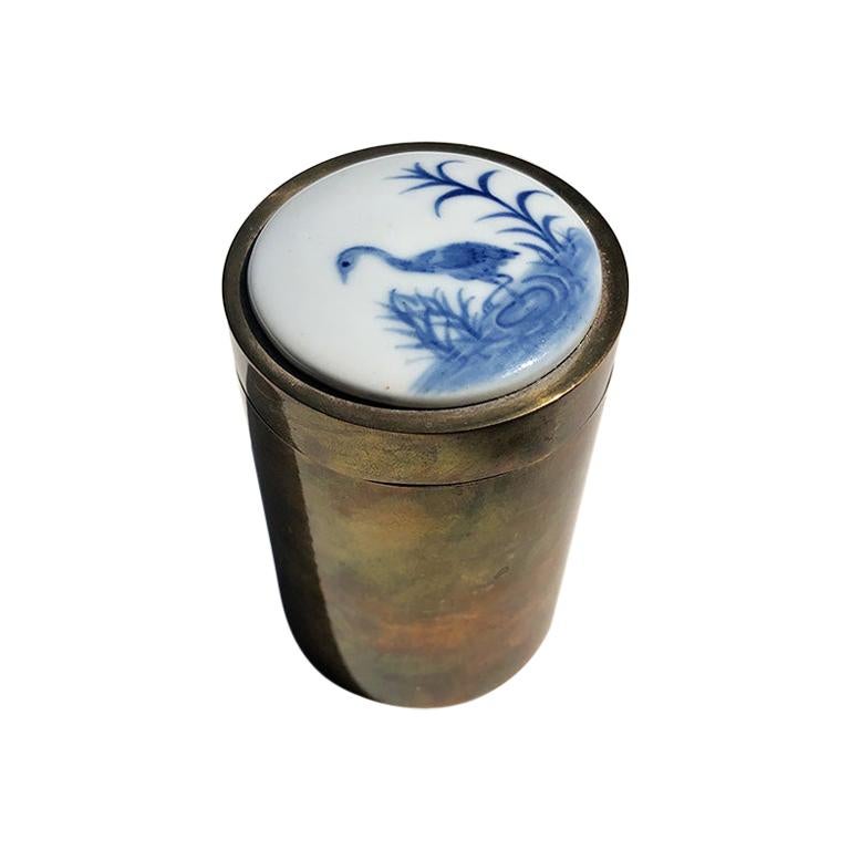 Contenitore rotondo in ottone con coperchio rimovibile in ceramica dipinta a gru
