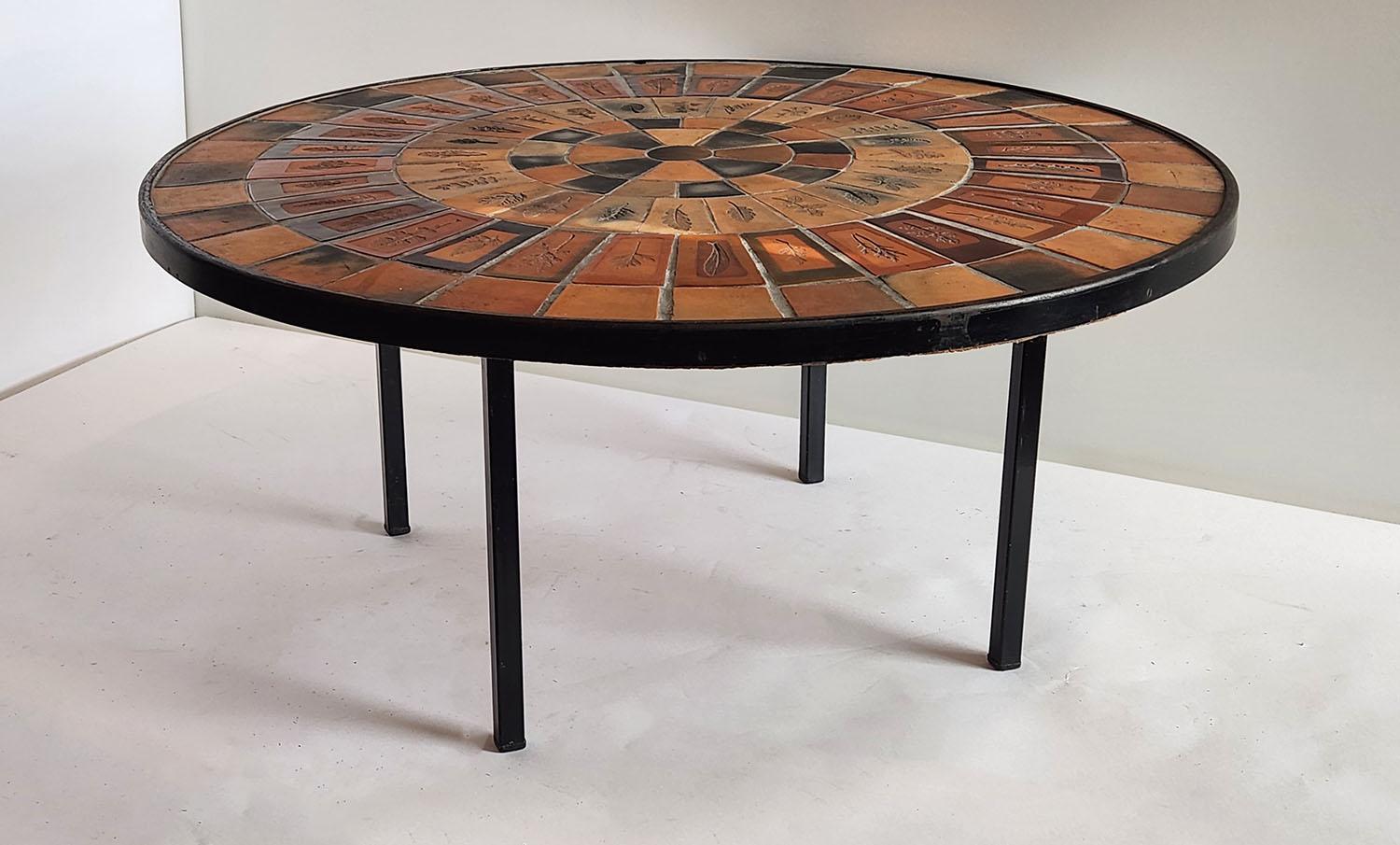 Round coffee table with the famous Roger Capron Herbier tiles, designed  from 1968 to 1982.

The handcrafted Herbier tiles were a subset of the Garrigue tiles produced by a technique in which real leaves were pressed into the clay and, during